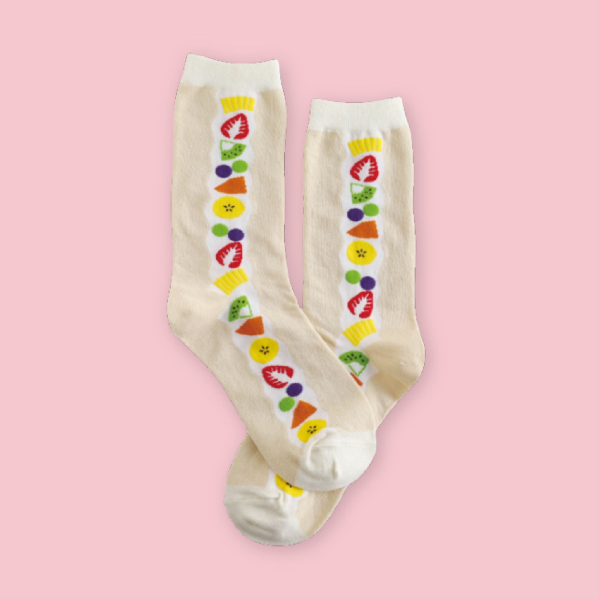 Garapago Socks in Fruit Sando style featuring colorful illustrated fruit pattern on cream crew socks on a pink background