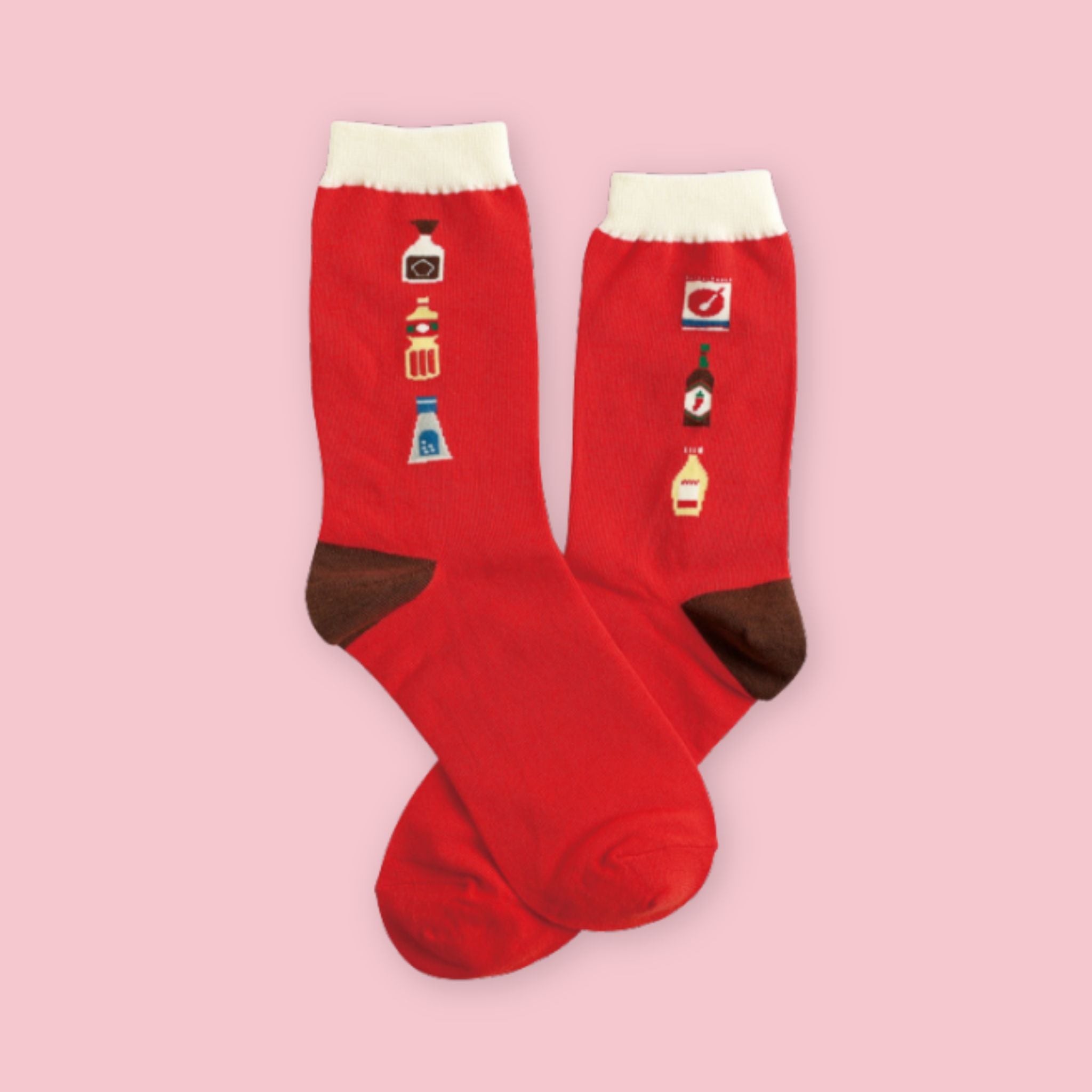 Pair of red crew socks featuring miniature Japanese condiment illustrations, including soy sauce, mayonnaise, and seasoning bottles, displayed on a pastel pink background.