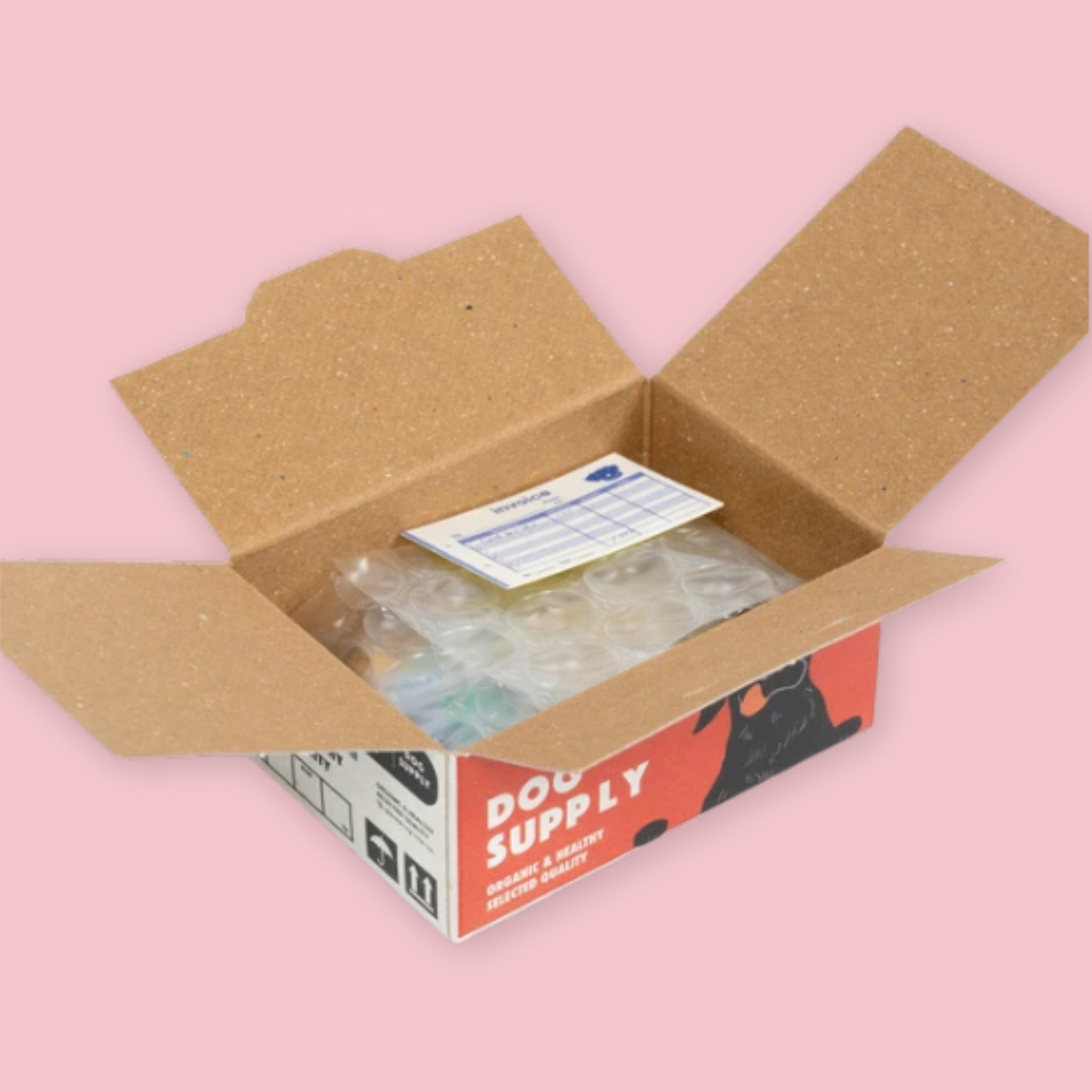 Open Hako sticker box showing bubble-wrapped stickers and an invoice inside, with the red and black Dog Supply packaging visible on the exterior, on a pink background.