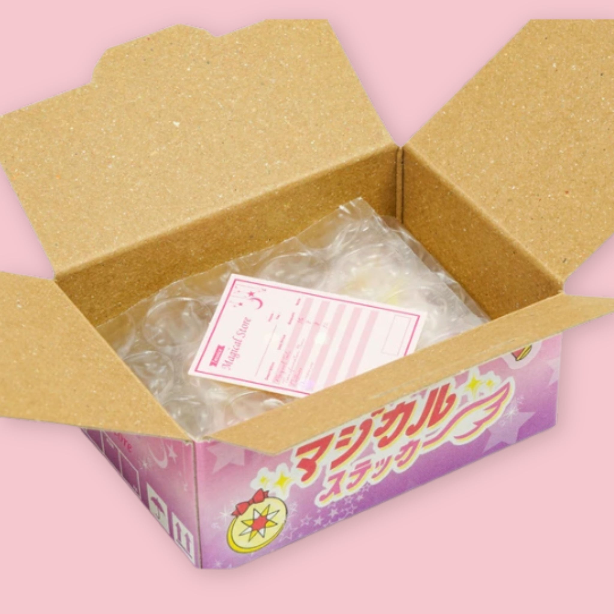 Open Hako sticker box showing bubble-wrapped stickers and a pink invoice inside, with the purple magical girl "Magical Sticker" packaging visible on the exterior, on a pink background.