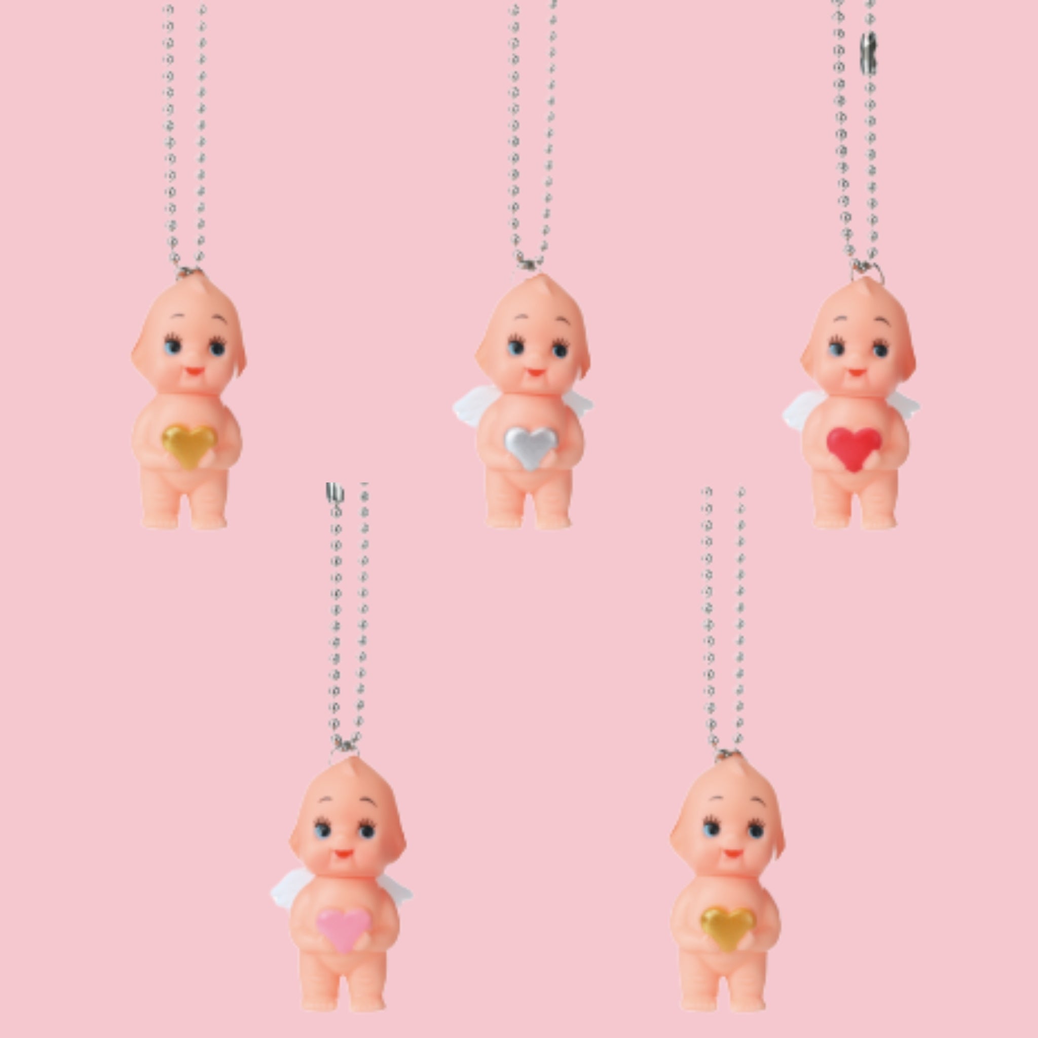 Obitsu Kewpie angel charms with ball chains, white wings, and heart accents in red, pink, gold, and silver on a pink background.
