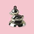 Stainless steel duck-shaped tea strainer on a pink background