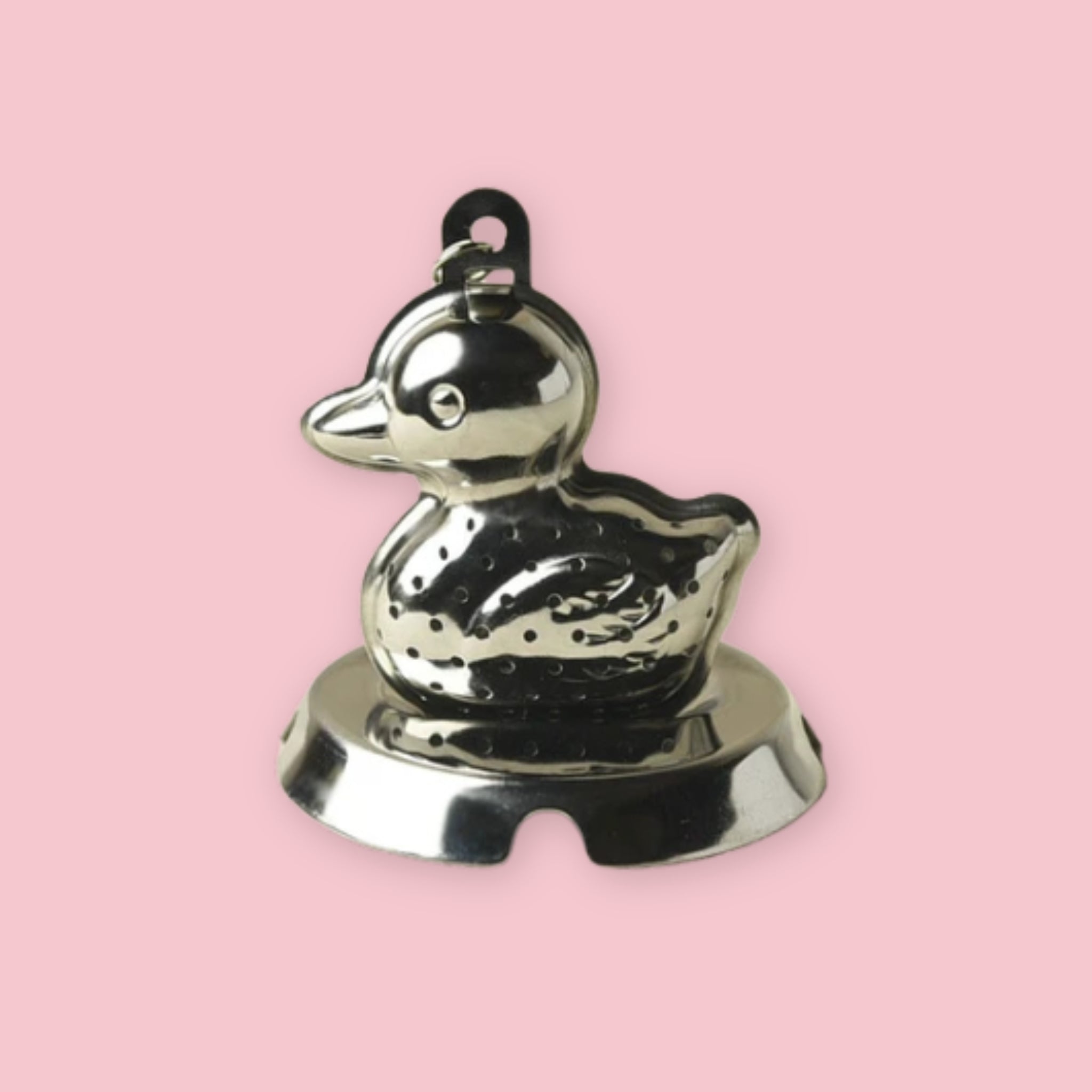 Stainless steel duck-shaped tea strainer on a pink background