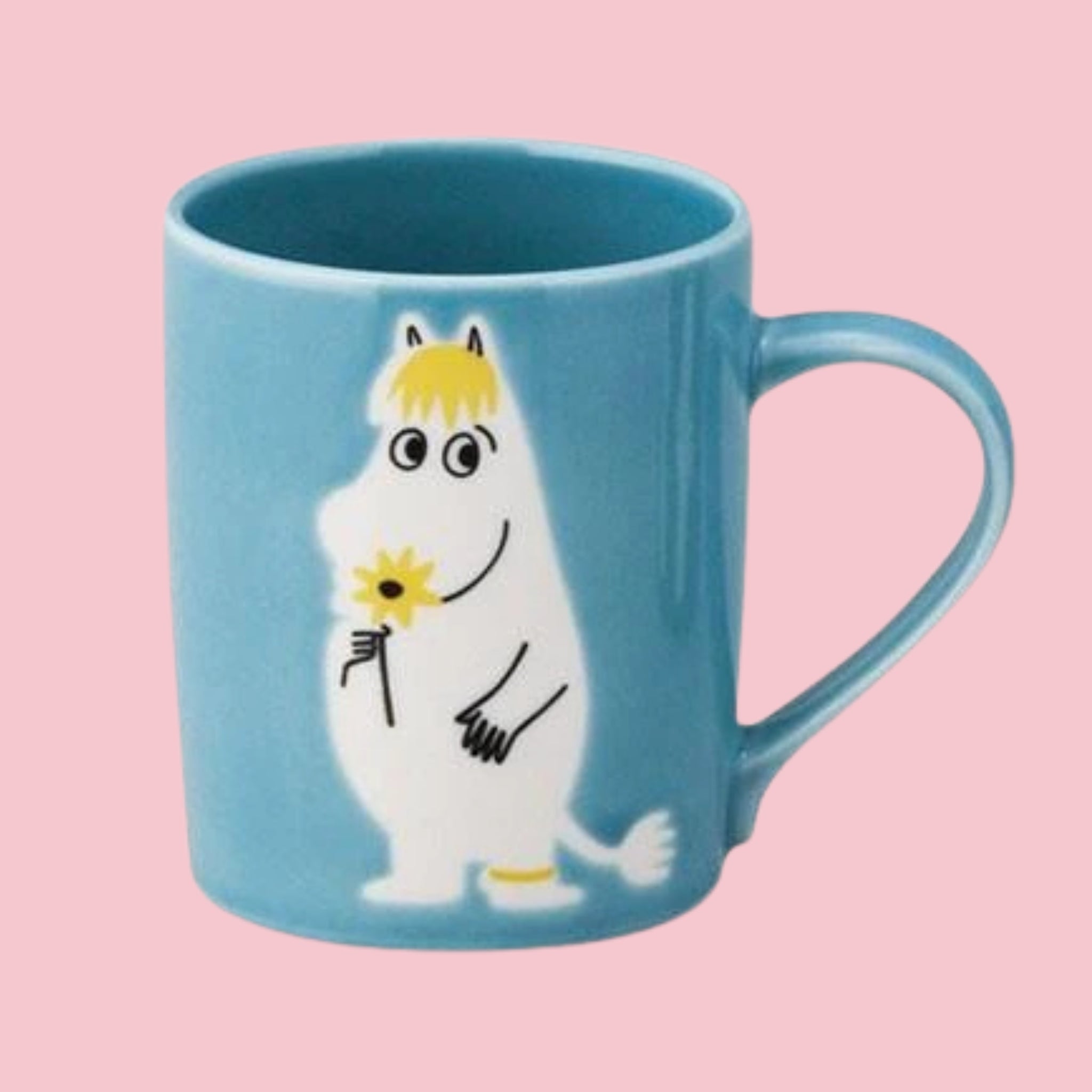 Blue Japanese Moomin mug with an embossed Snorkmaiden holding a sunflower, on a pink background