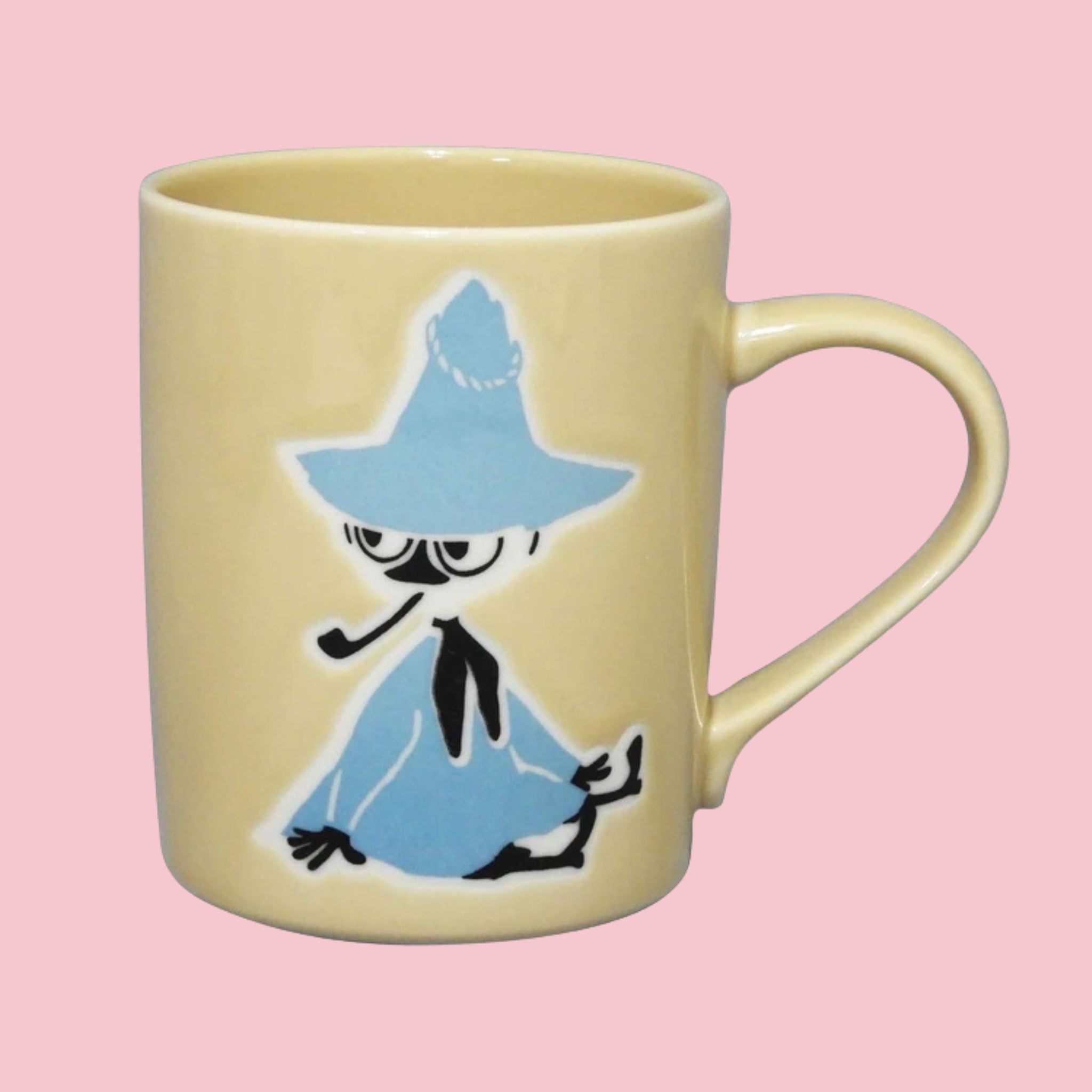 Beige Japanese Moomin mug with an embossed Snufkin in his iconic blue coat and hat, on a pink background