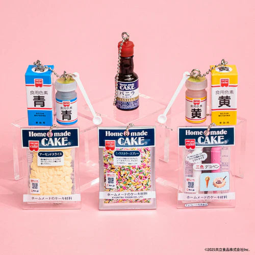 Home Made Cake miniature mascot charms featuring Japanese baking supplies, including almond slices, sprinkles, deco pens, vanilla essence, and food coloring, displayed on a pink background.
