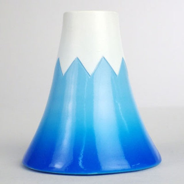 Backside of Kewpie doll dressed as Mount Fuji, with a blue mountain-shaped hood.