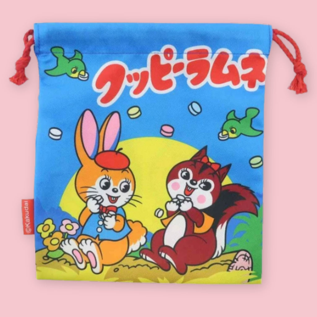 Kuppy Ramune drawstring bag with rabbit and squirrel characters, red cords, candy illustrations, and Japanese logo text.