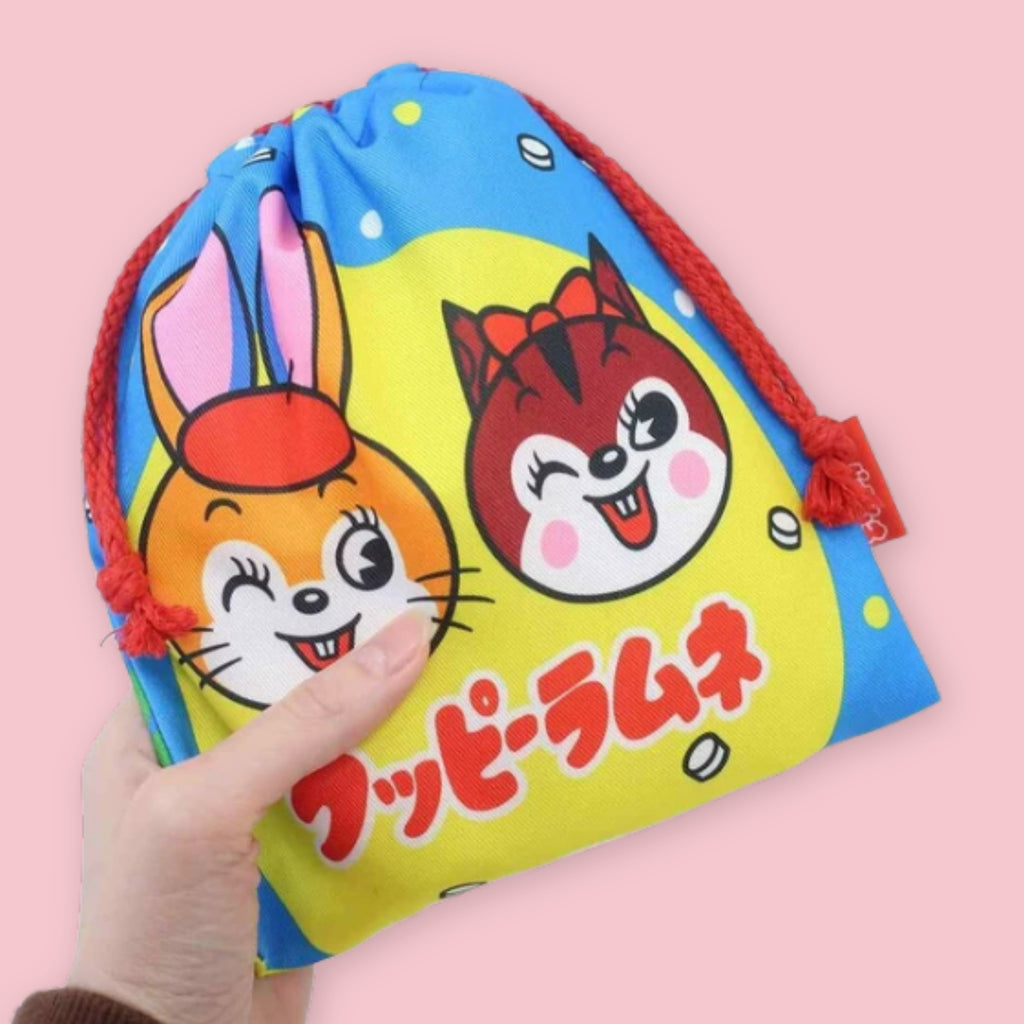 Kuppy Ramune drawstring bag with colorful rabbit and squirrel characters, red cords, and Japanese logo text.