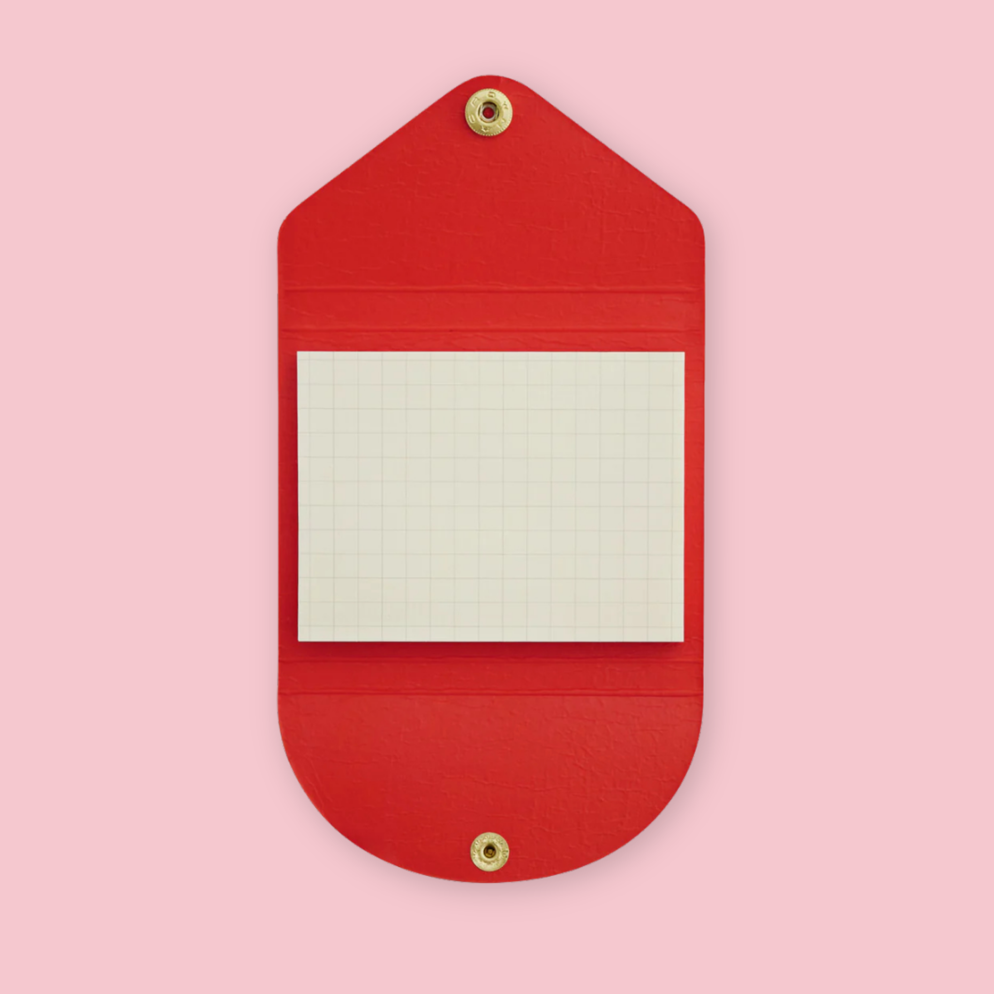 Red faux leather sticky note pouch shaped like an envelope, open to show grid paper notepad inside, snap closures top and bottom, on a pink background.