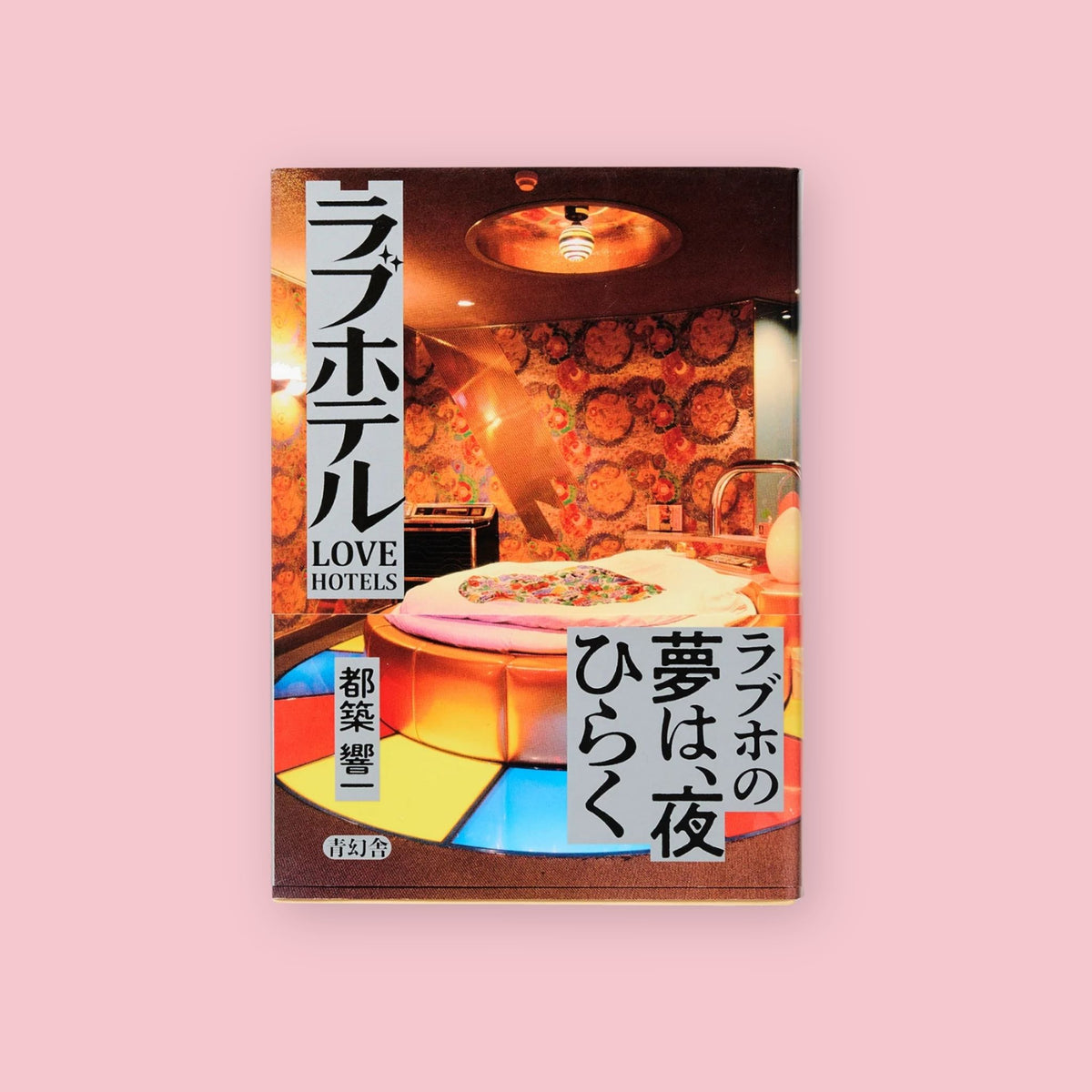 Japanese “Love Hotels” book with retro hotel room photography on a pink background.