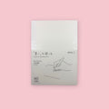 Midori MD Notebook with A6 blank pages and minimalist white cover, photographed against a pastel pink background.