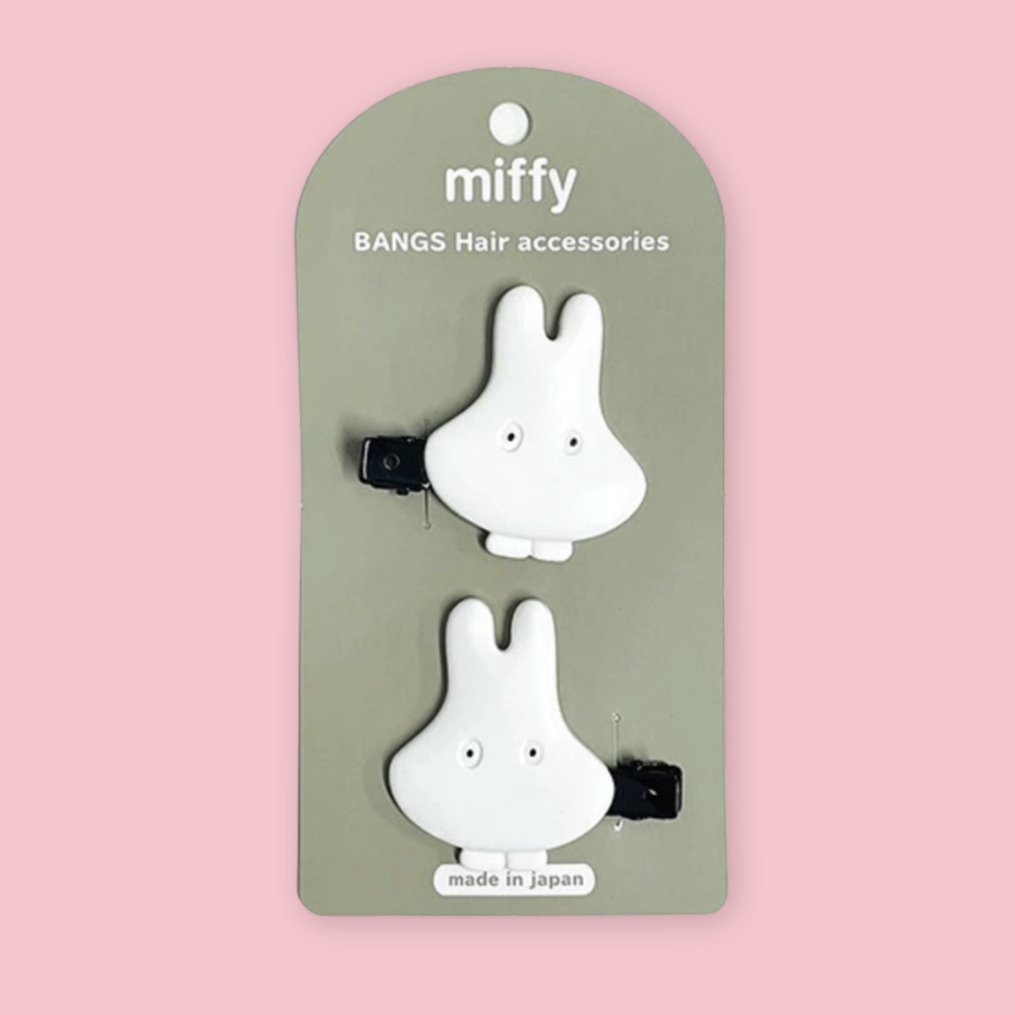 Miffy hair clips set with two white Miffy Ghosts on a green backing card, shown on a pink background.
