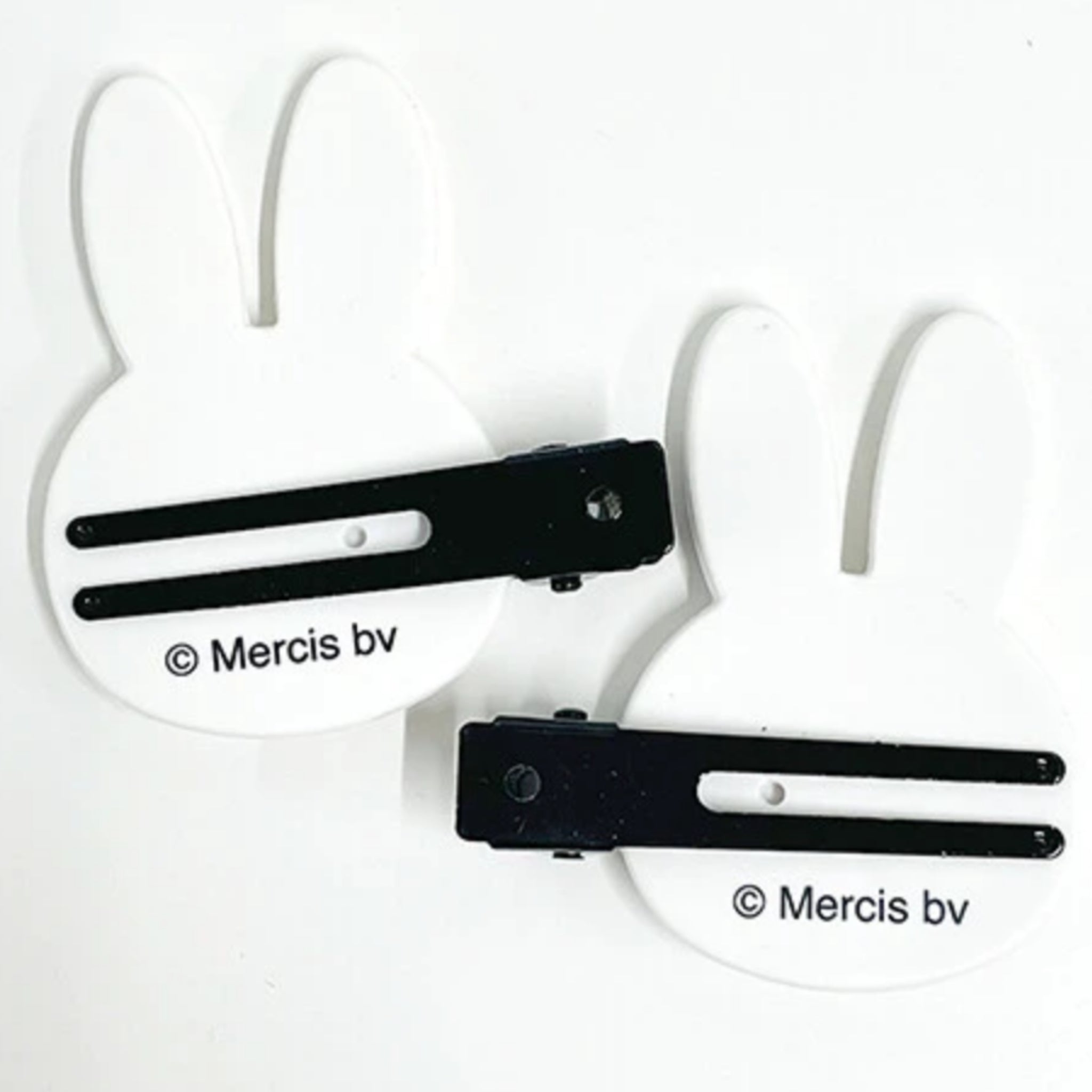 Two white Miffy-shaped hair clips with black metal bars and the printed brand name 'Mercis bv' on a plain white background.