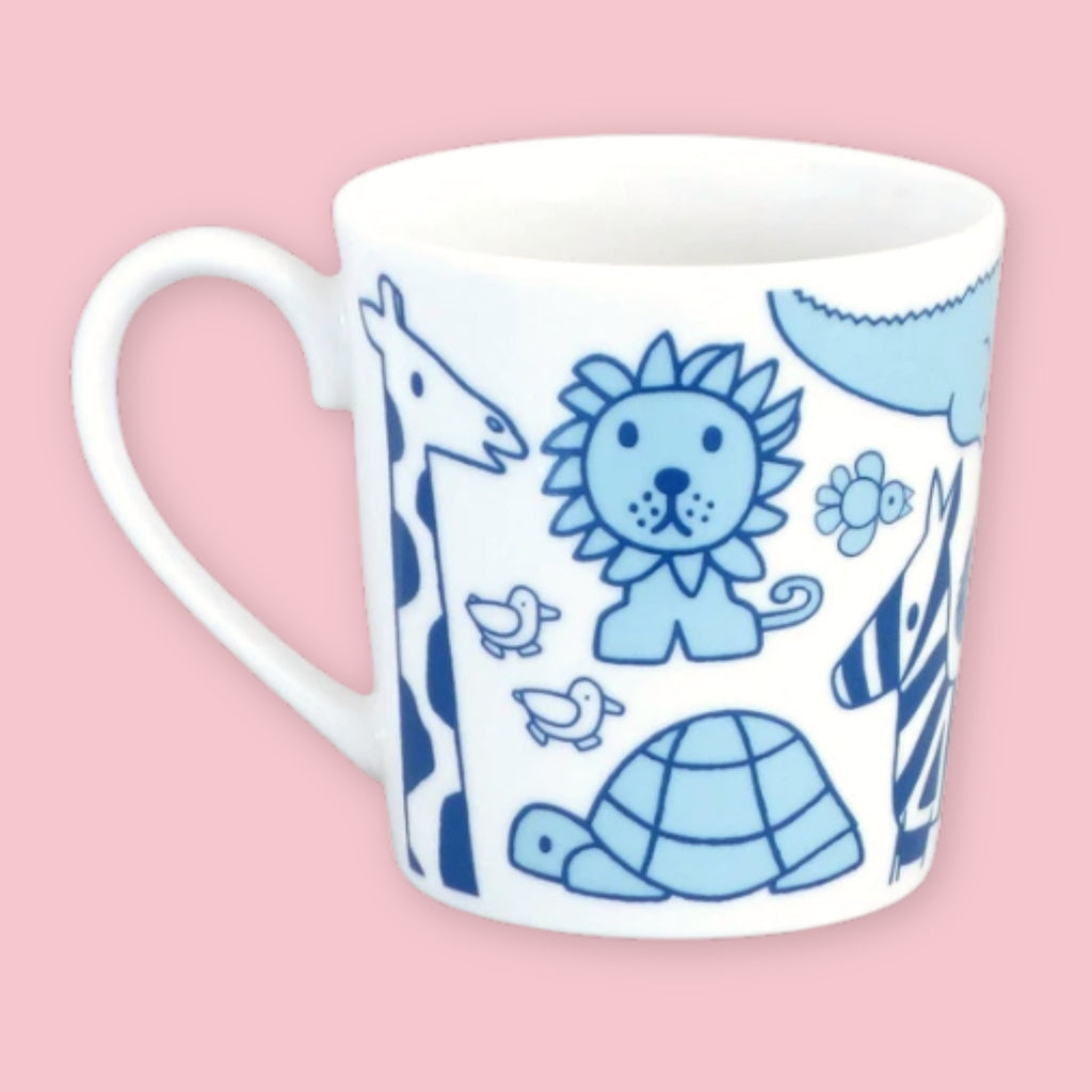 White mug printed with blue "Miffy and Animals" illustrations including a giraffe, lion, zebra, turtle, and birds, against a pink background