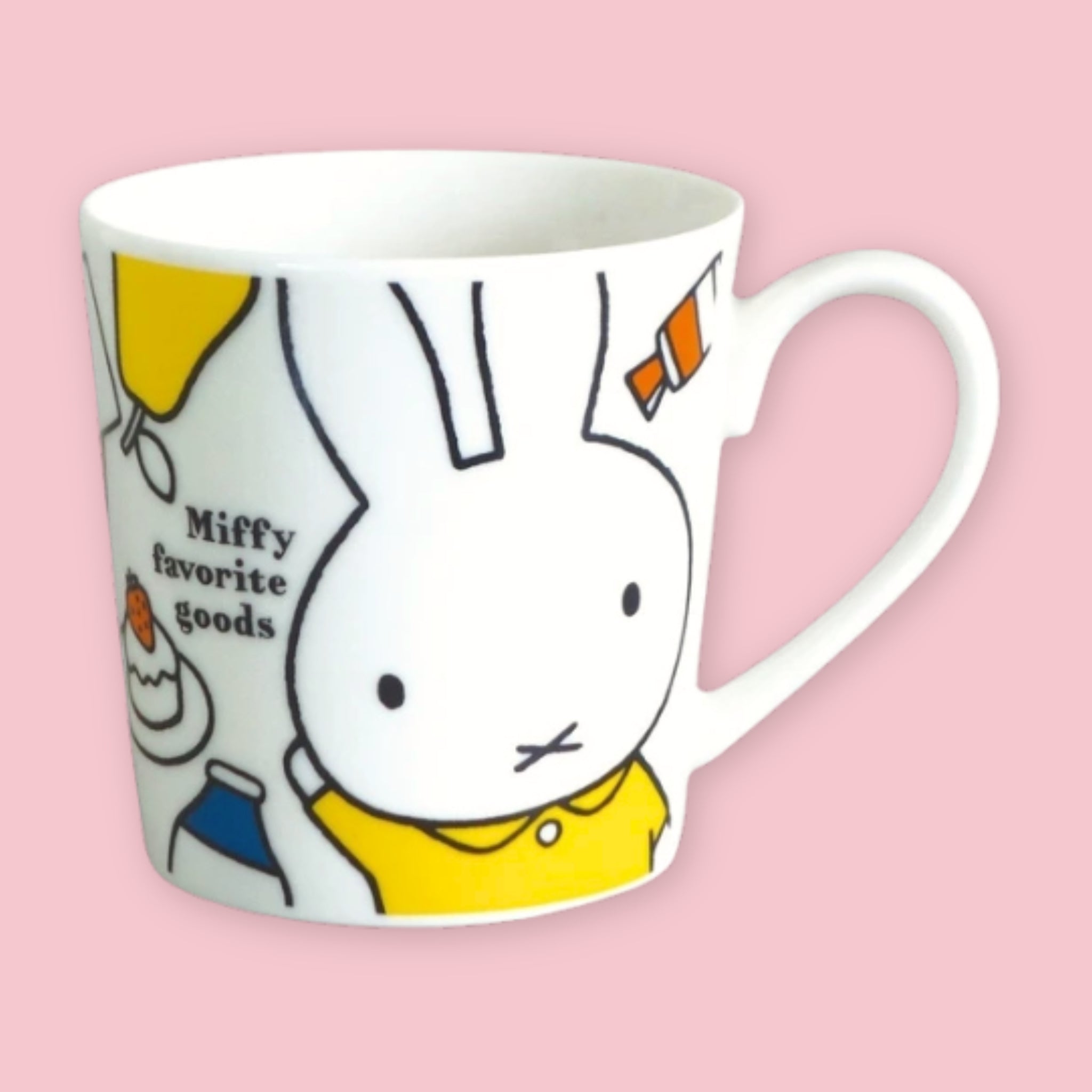 White mug printed with a large Miffy face in a yellow shirt alongside "Miffy favorite goods" text and small illustrations of everyday objects, against a pink background