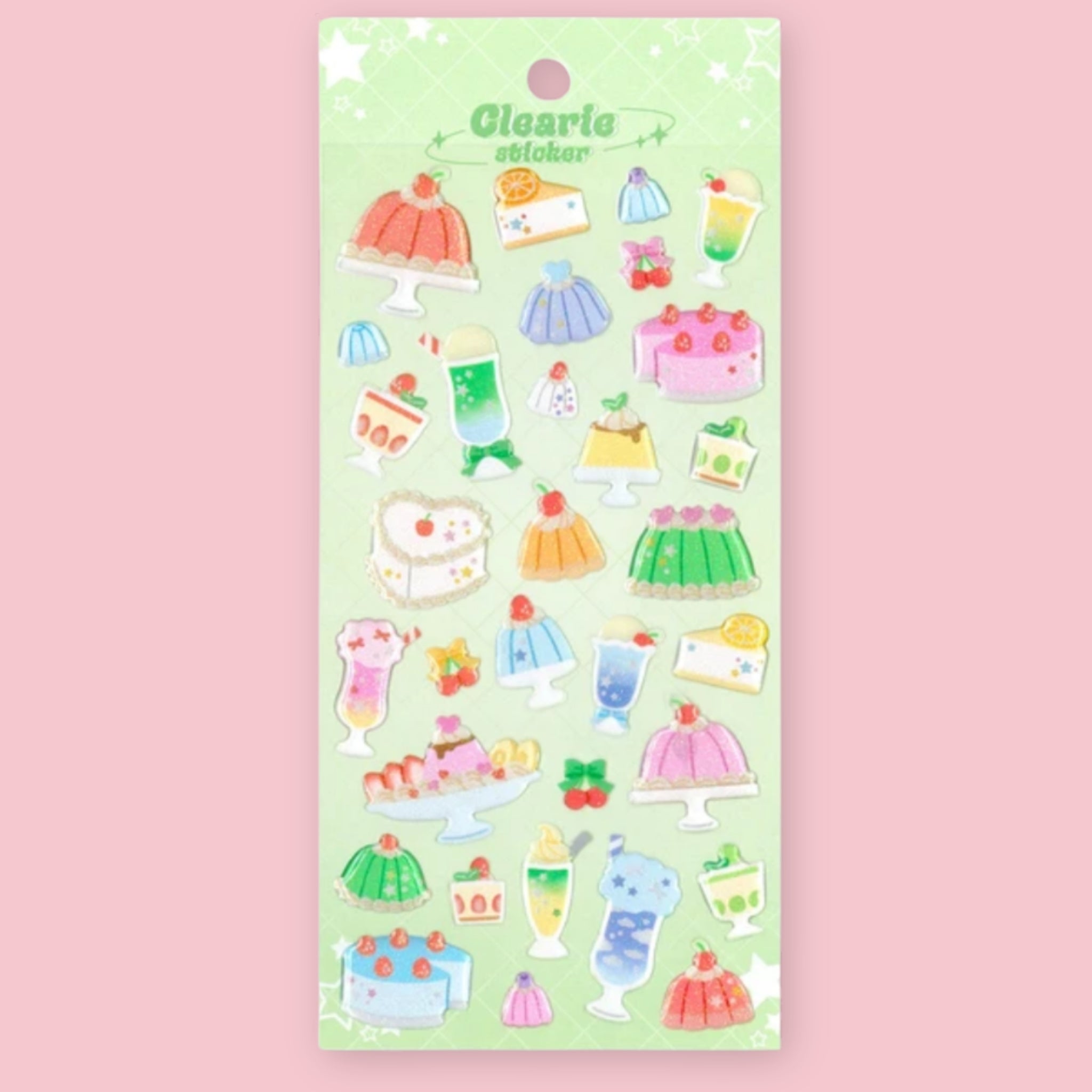 A sheet of cute dessert-themed stickers on a light green backing card, set against a solid pink background. The stickers feature various illustrated cakes, puddings, and drinks in pastel colors.