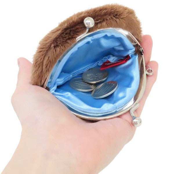 Monchhichi plush coin purse shown open in a hand, with blue satin lining, silver clasp, and coins inside.