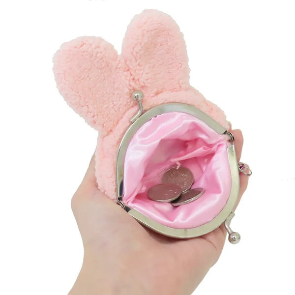 Monchhichi plush coin purse shown open in a hand, with pink satin lining, silver clasp, and coins inside.