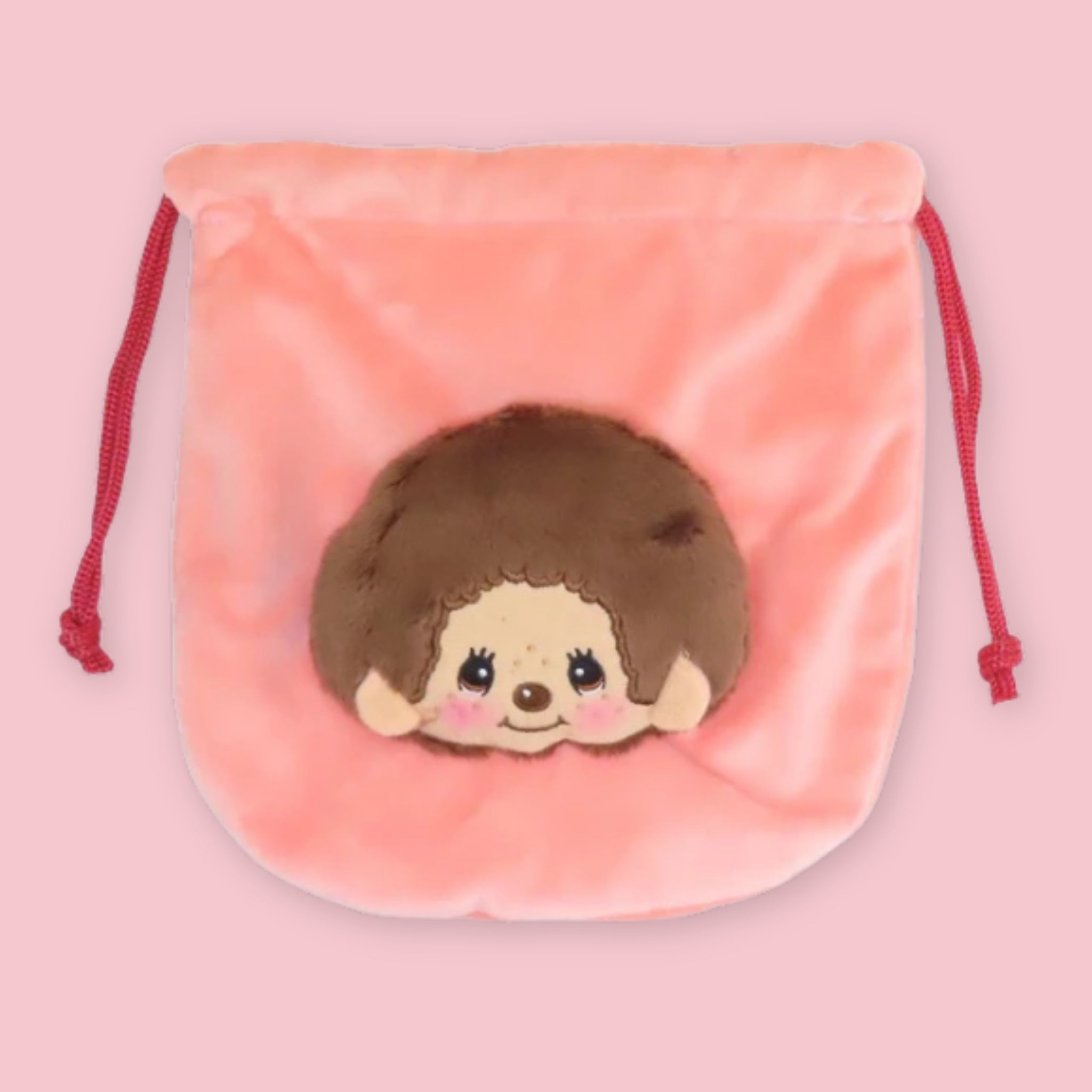 Monchhichi plush drawstring pouch in coral, with a soft monkey face on the front.