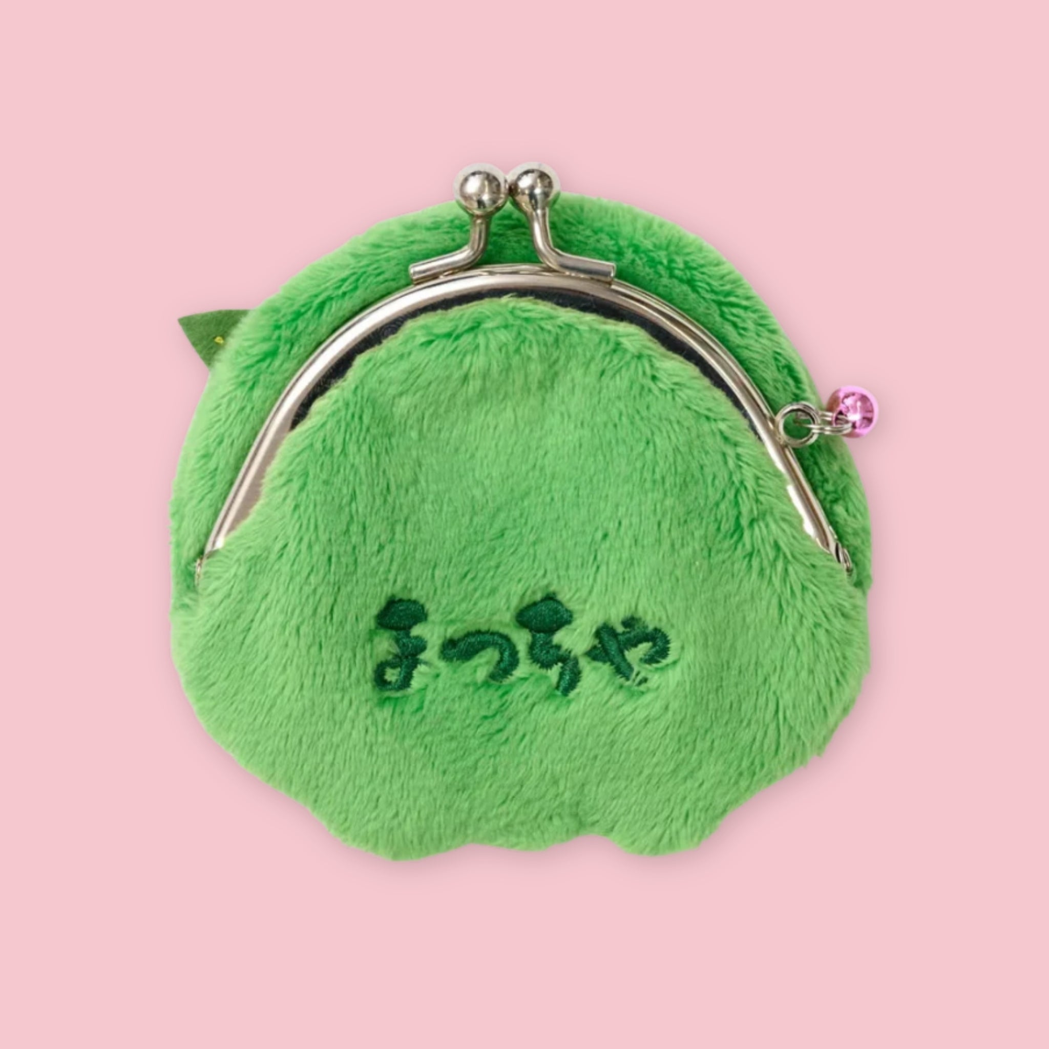 Dark green Monchhichi matcha coin purse with silver kiss-lock clasp and embroidered Japanese text on the back, shown on a pink background.