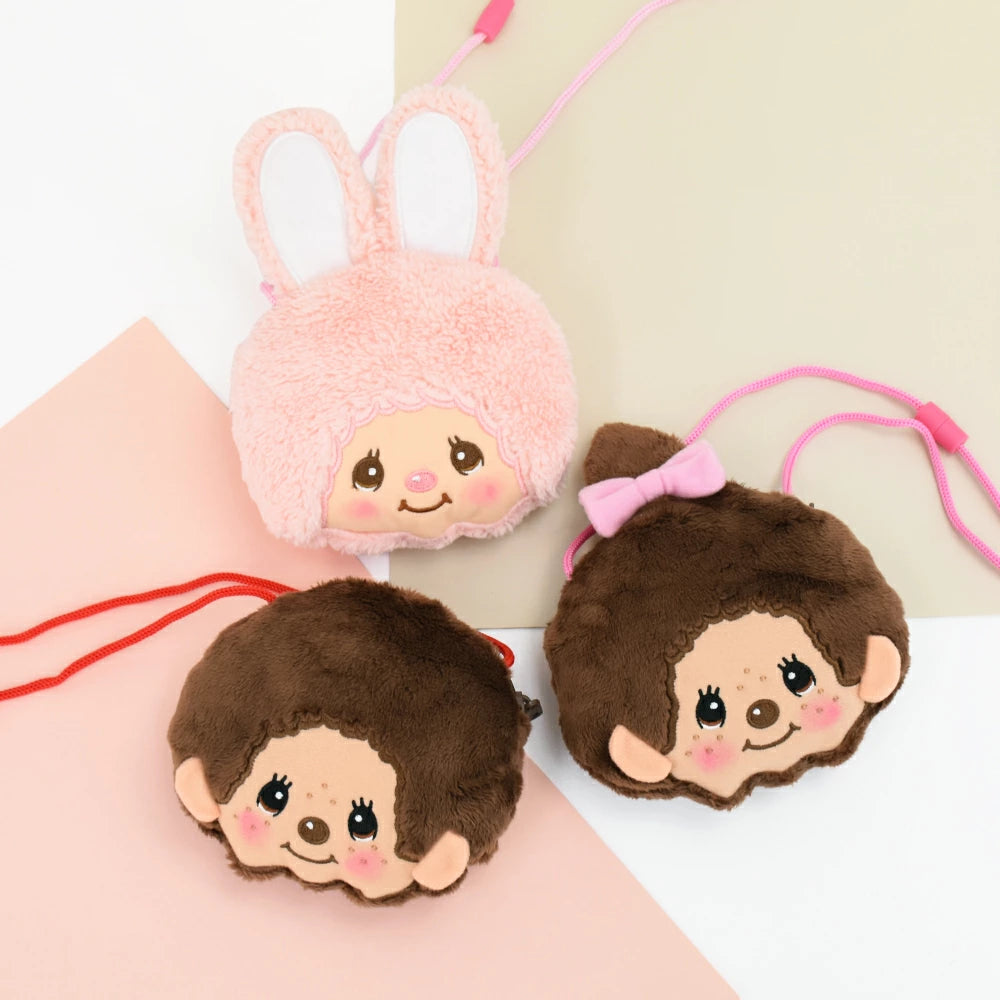 Three Monchhichi plush neck pouches, including Chimutan bunny and Monchhichi styles, arranged on a pastel background with pink and red shoulder cords.