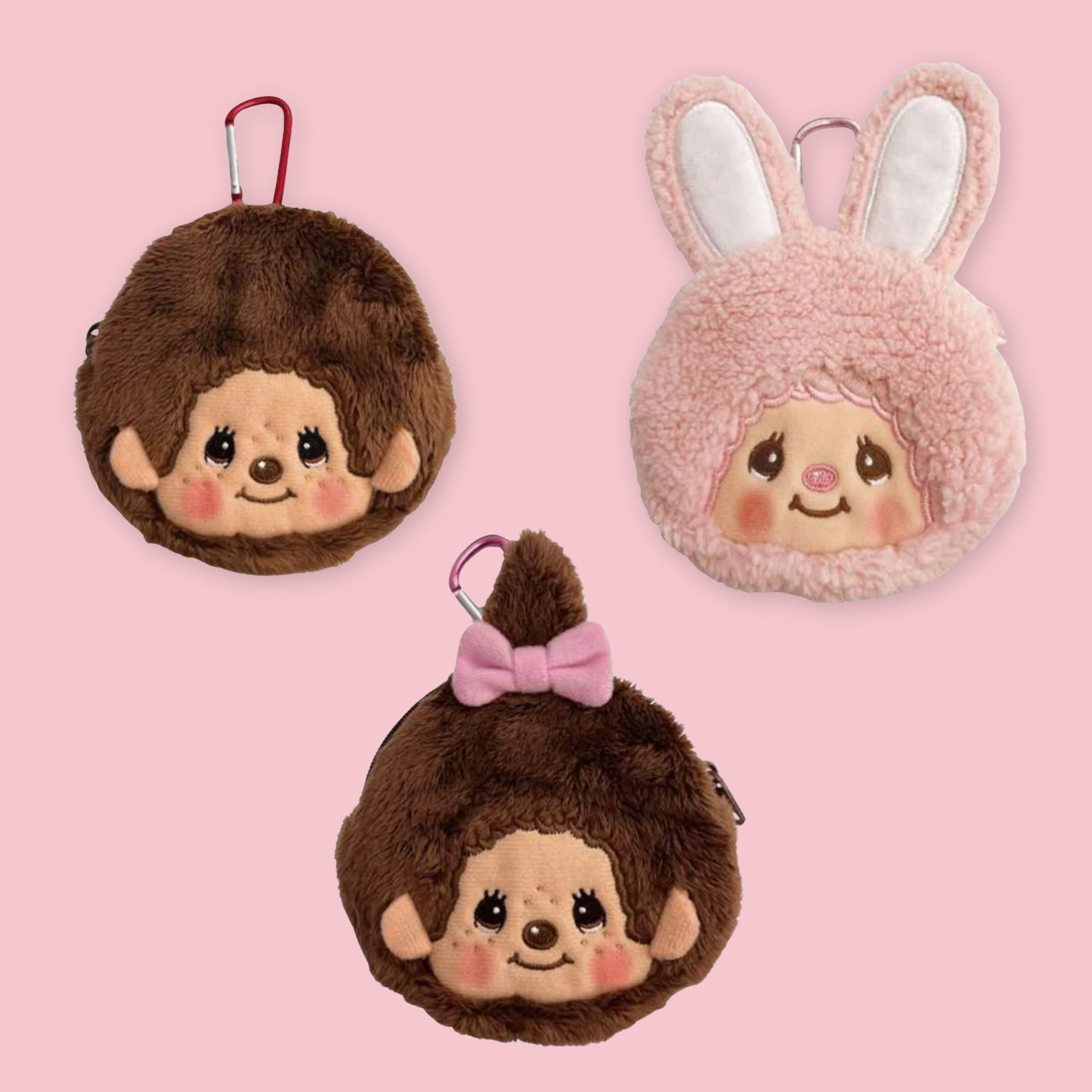 Three Monchhichi mini pouches with carabiner clips: Monchhichi-kun, Chimtan in pink with rabbit ears, and Monchhichi-chan with a pink bow, against a pink background
