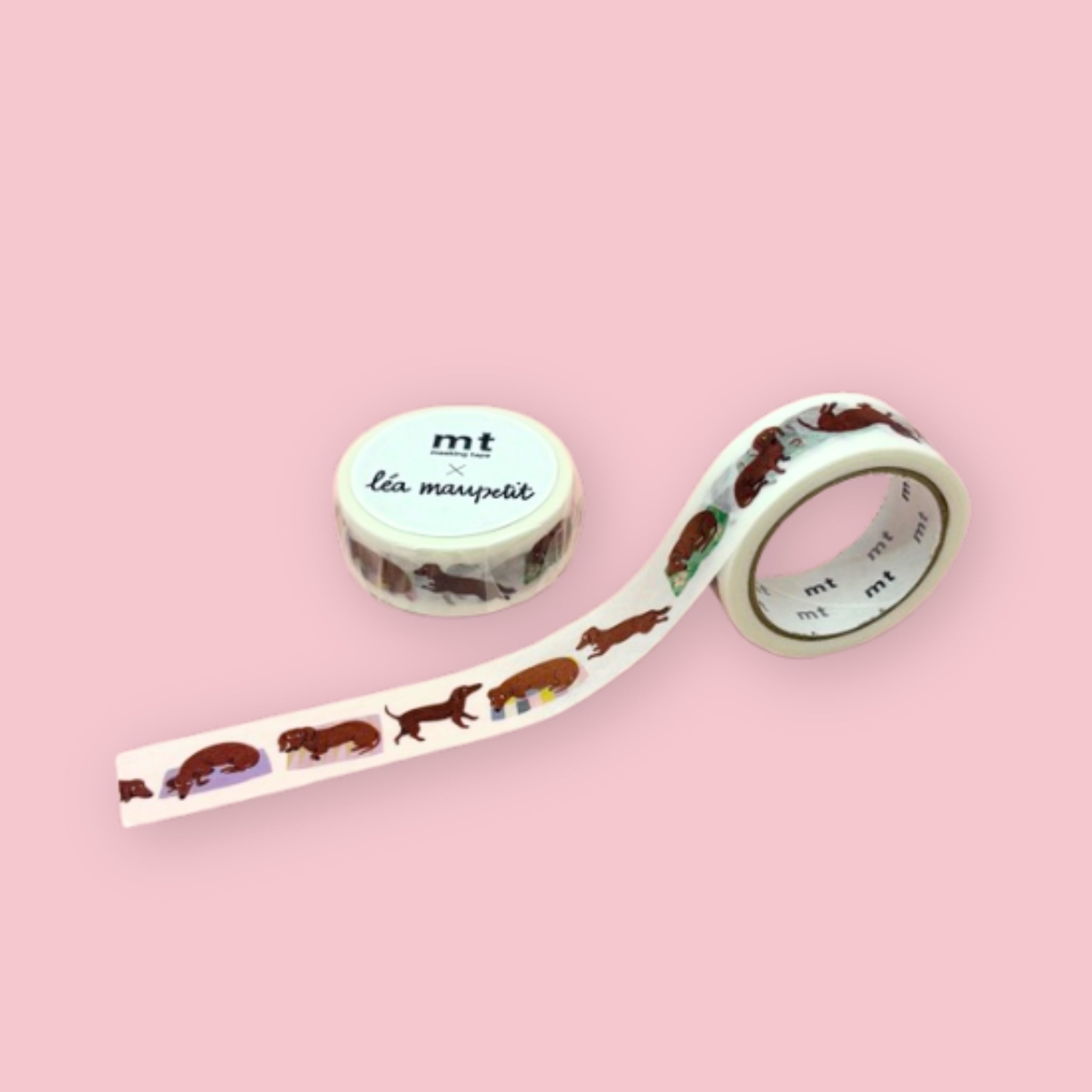 Two rolls of mt x Léa Maupetit washi tape with illustrated sausage dogs and colorful dog coats on a pastel pink background.
