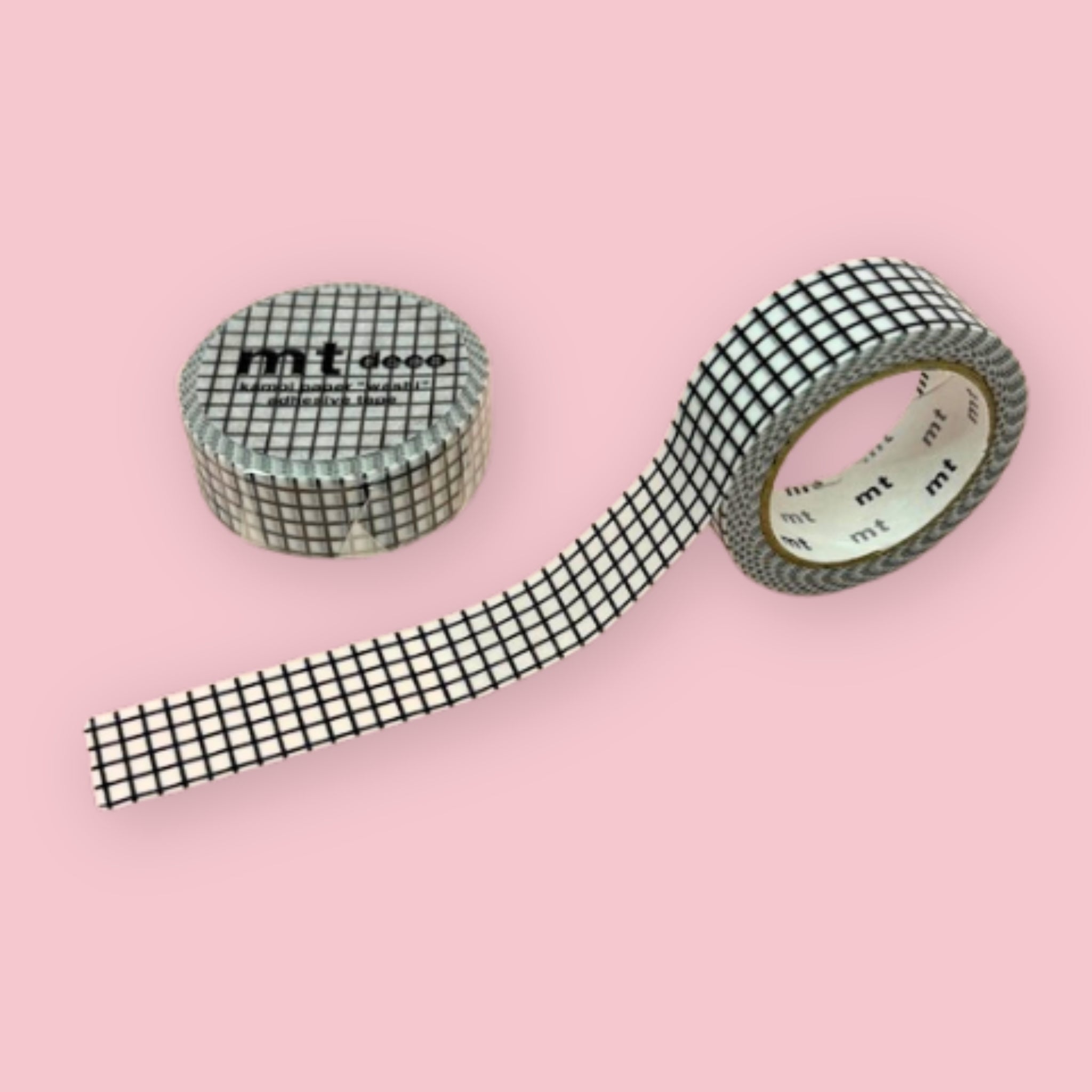 Two rolls of mt deco washi tape with a black grid pattern on a white background, photographed on pastel pink.