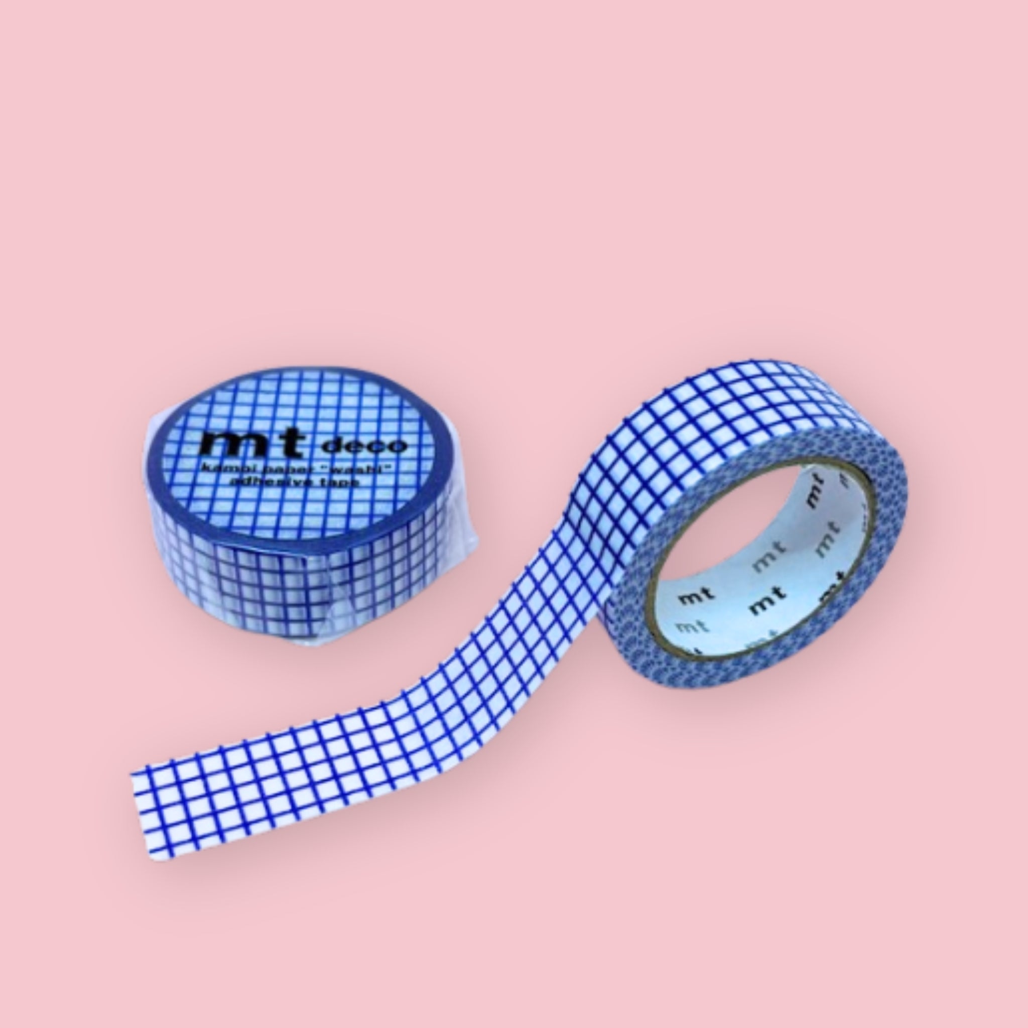 Two rolls of mt deco washi tape with a blue grid pattern on a white background, photographed on pastel pink.