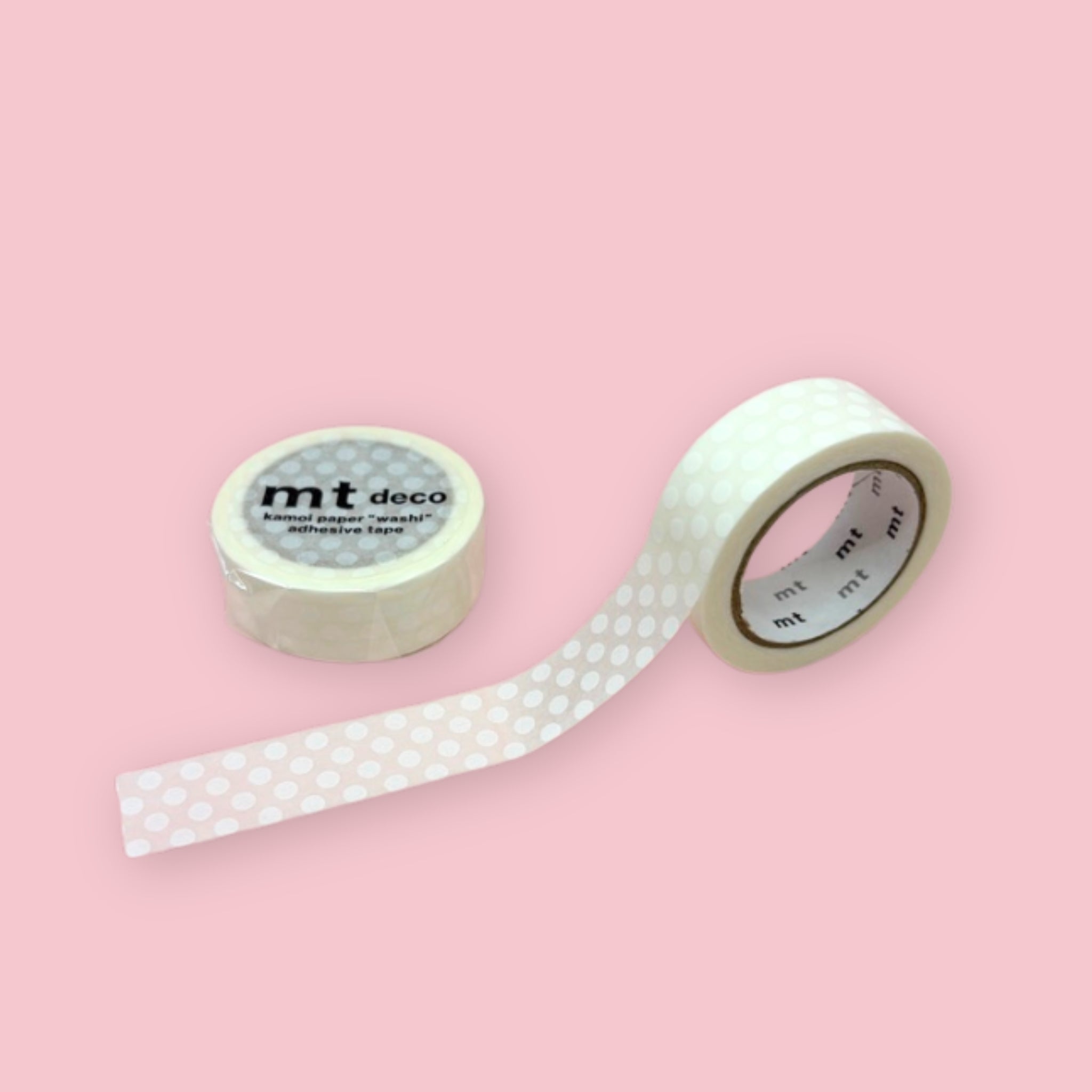 Two rolls of white mt deco washi tape with a white polka dot pattern on a pastel pink background.