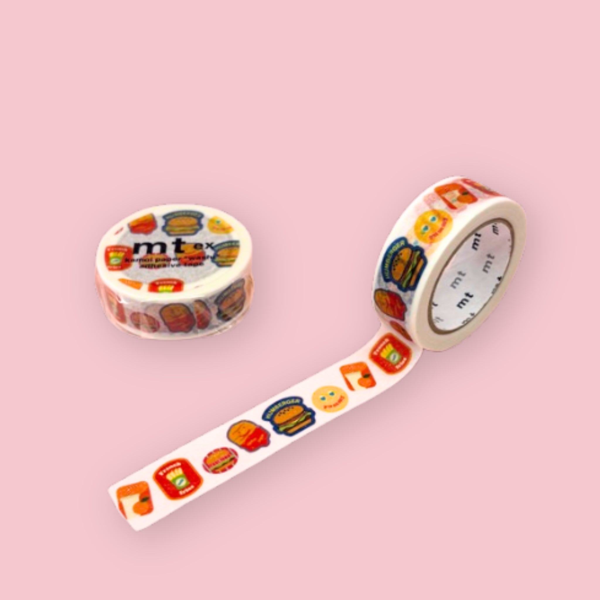White mt washi tape with colorful fast food icons, including hamburgers, fries, ketchup, and drinks, shown partly unspooled beside a wrapped roll on a pink background.