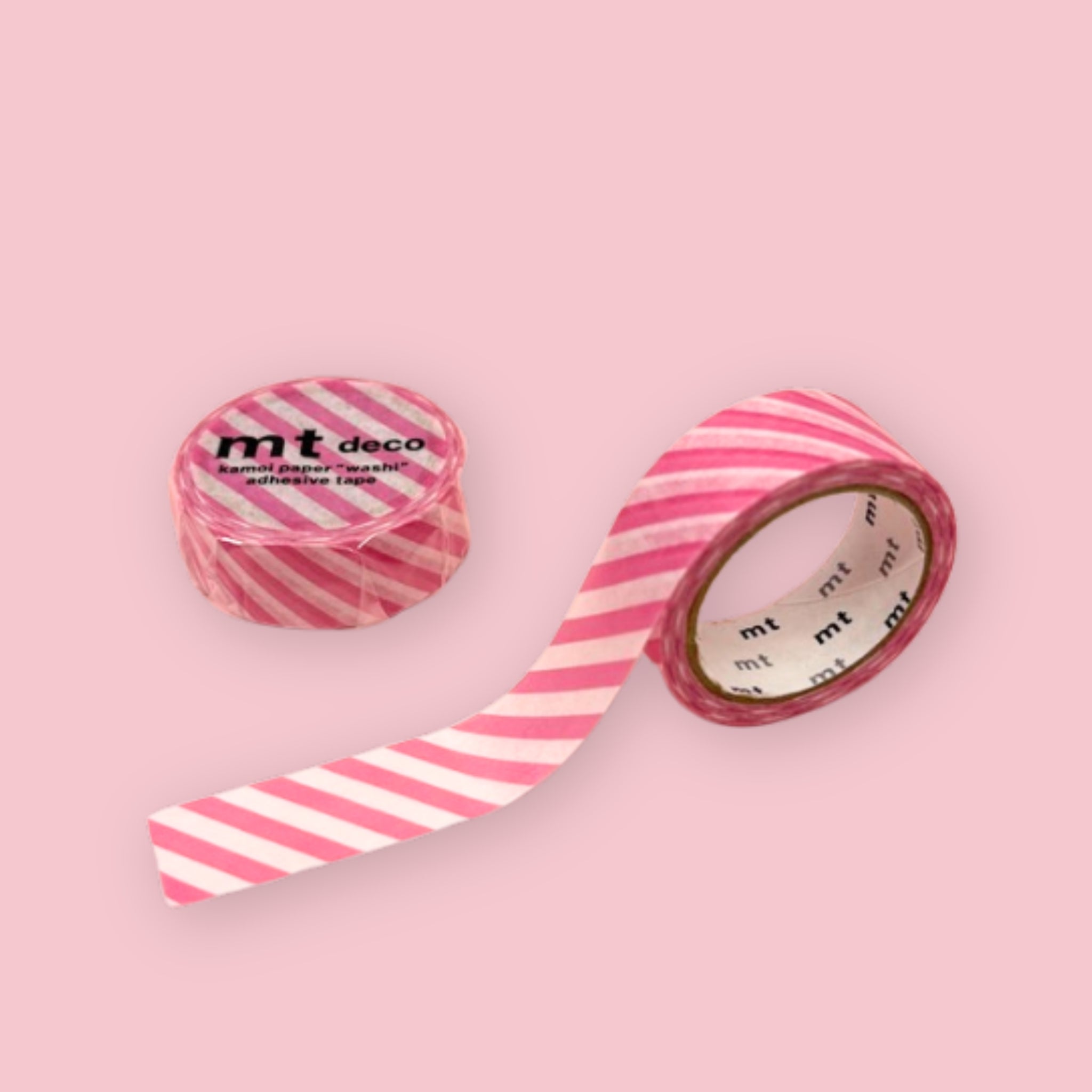 Two rolls of mt deco washi tape with pink and white diagonal stripes on a pastel pink background.