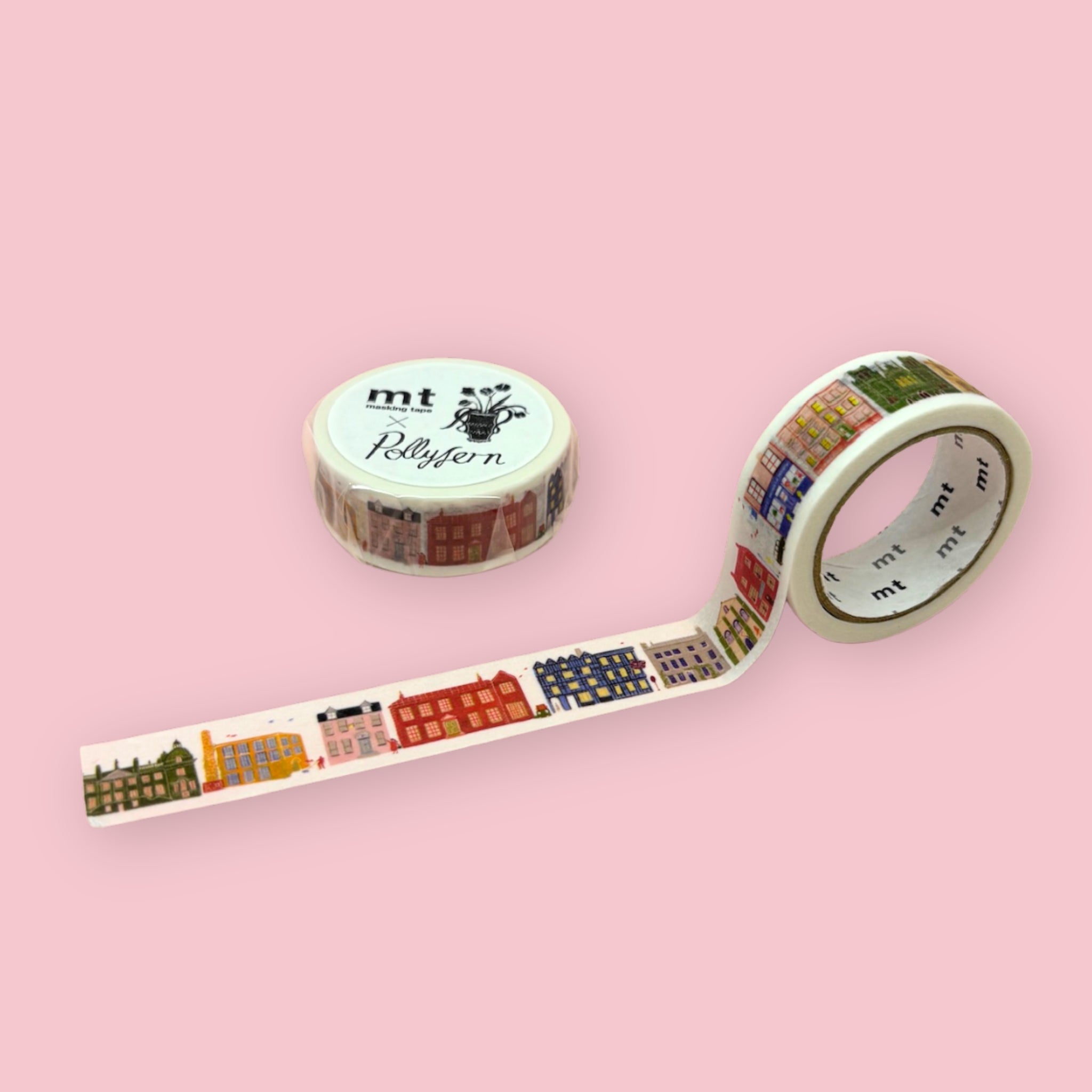 mt x Polly Fern washi tape with colorful illustrated buildings, shown partly unspooled beside a wrapped roll on a pink background.