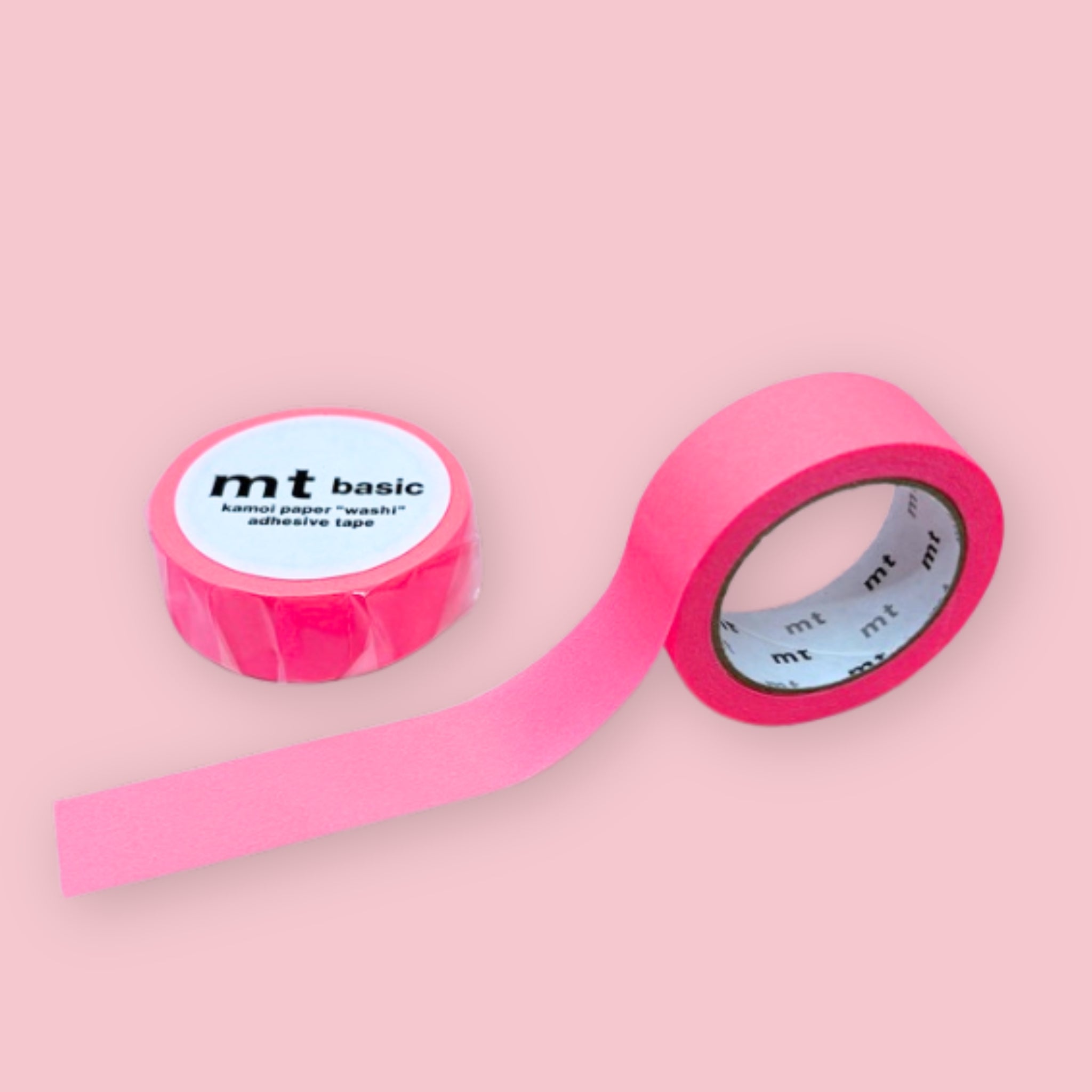 Two rolls of bright pink mt basic washi tape on a pastel pink background.