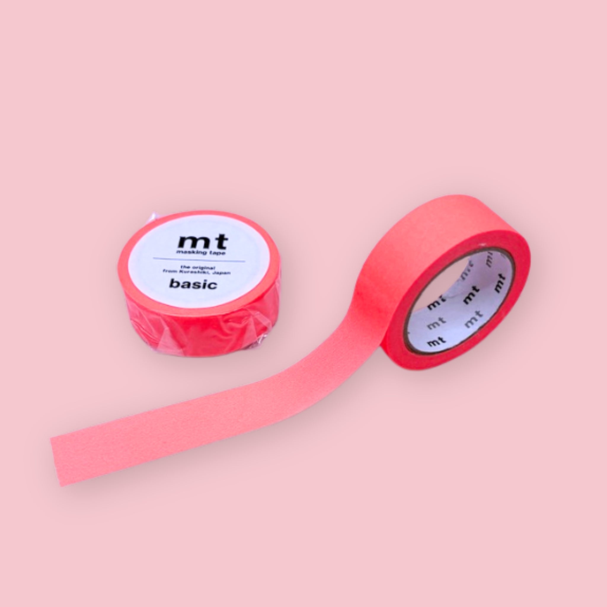 Two rolls of neon red mt basic washi tape on a pastel pink background.