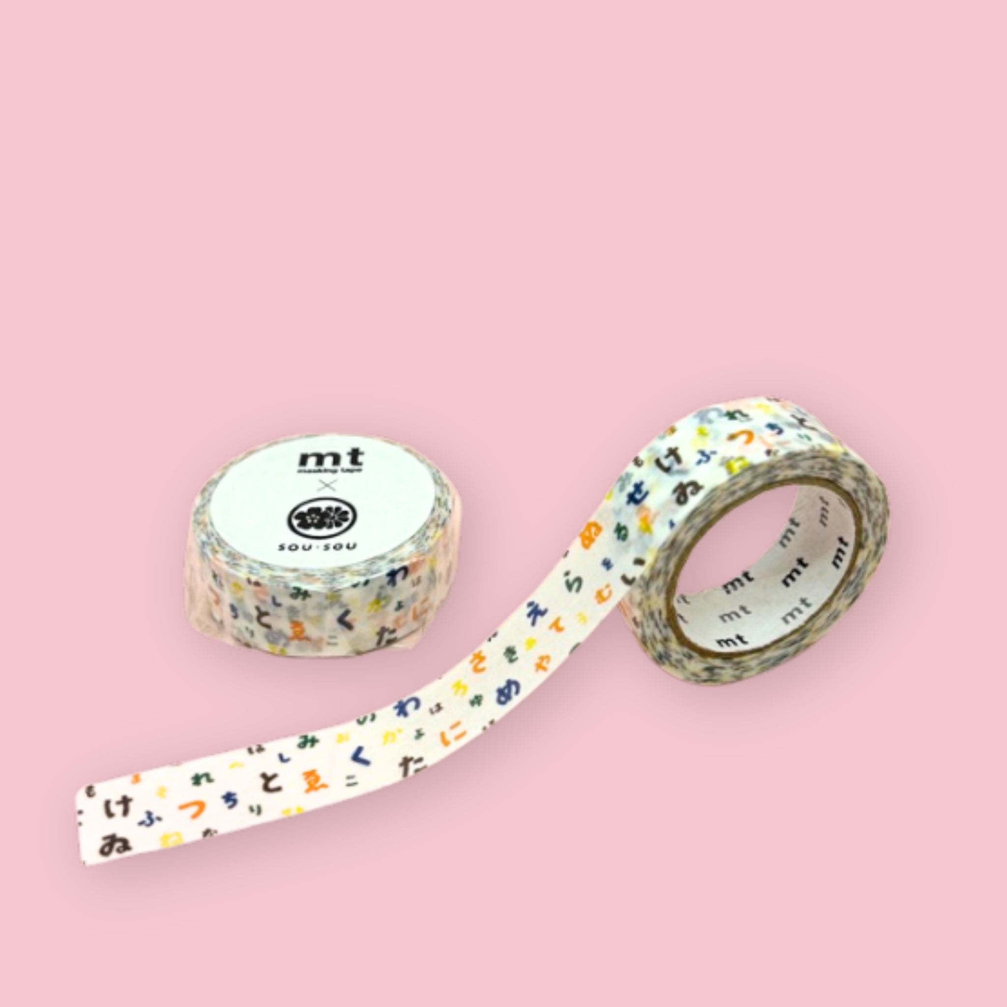 Two rolls of mt x sou sou washi tape with colorful Japanese hiragana characters on a white background, photographed on pastel pink.