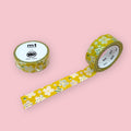 Two rolls of mt x sou sou washi tape with white floral patterns on a mustard yellow background, photographed on pastel pink.