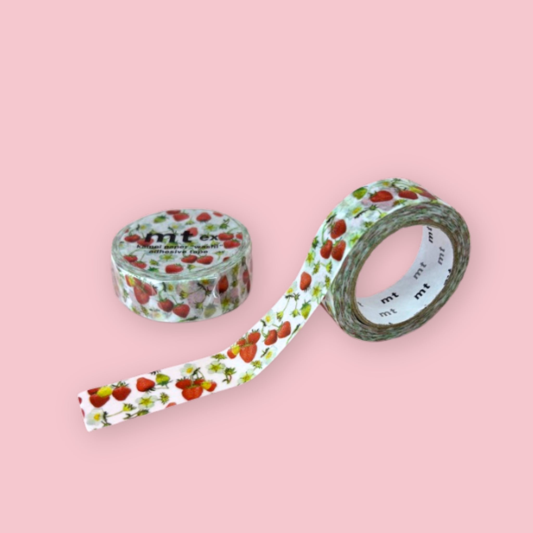 Two rolls of mt ex washi tape decorated with red strawberries, blossoms, and green leaves on a white background, photographed on pastel pink.