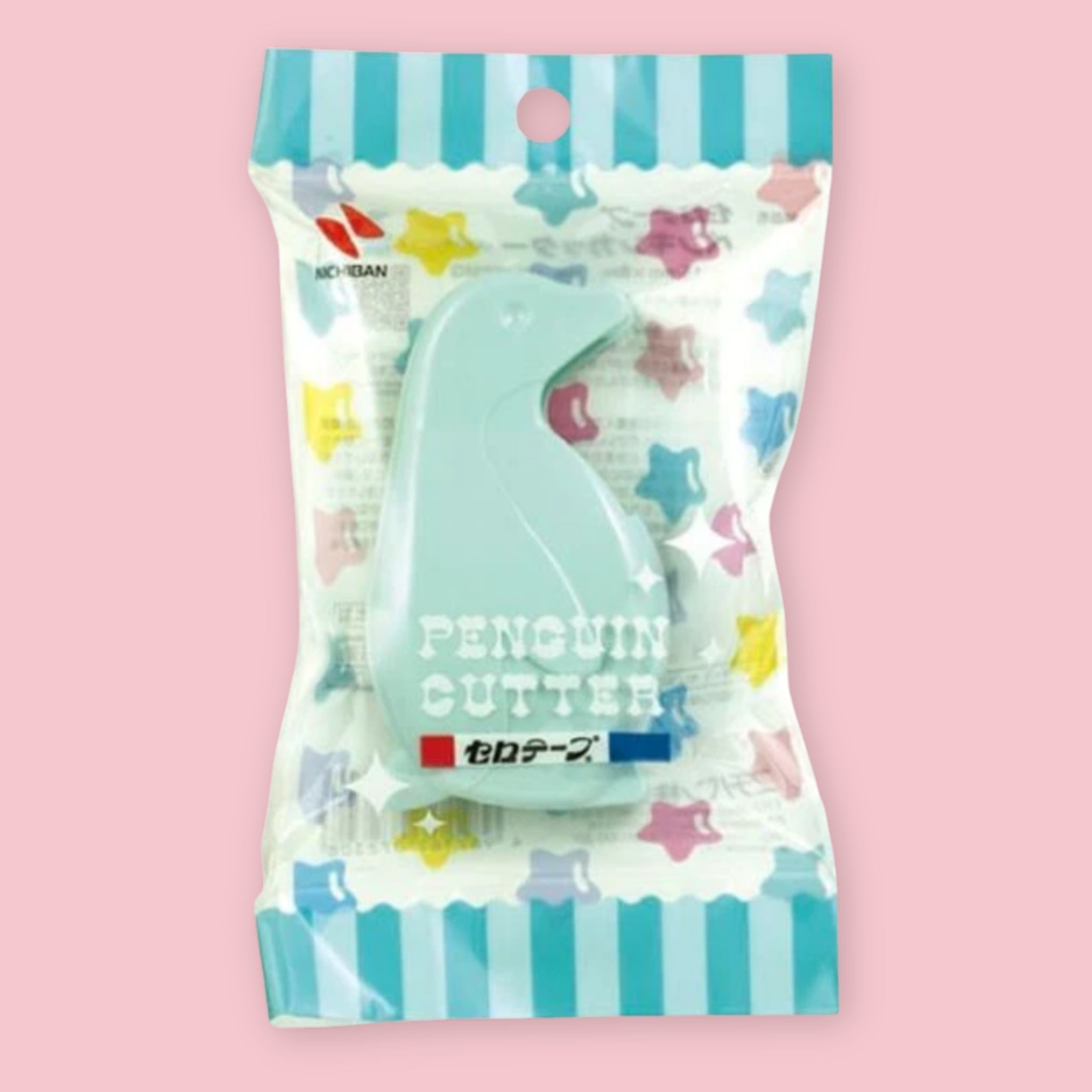 A packaged penguin-shaped tape dispenser in a clear plastic bag with a pastel striped top and multicolored star print. The cutter itself is mint green, and the packaging includes the text 'PENGUIN CUTTER' and a small 'NICHIBAN' brand mark.