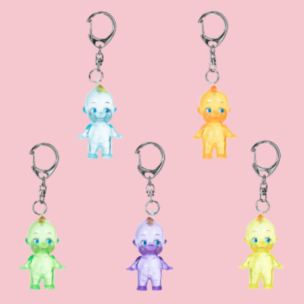 Clear-color Obitsu Kewpie keychains in blue, orange, green, purple, and yellow on a pink background.
