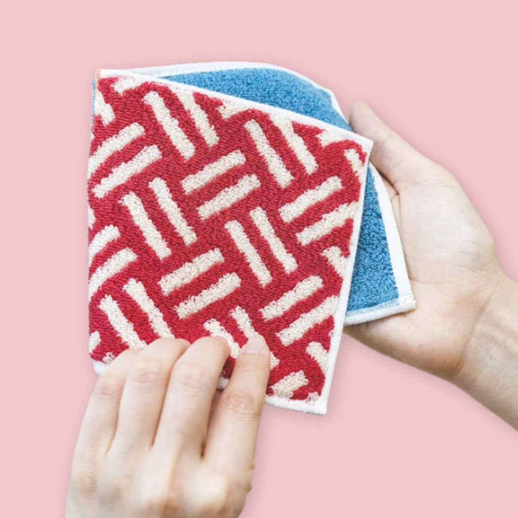 Hands demonstrating the Otta Imabari Half Towel center fold, showing compact folded size versus full unfolded towel, Made in Japan