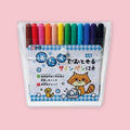 Sakura washable marker set of 12 in clear zip pouch with blue gingham label featuring a raccoon washing clothes illustration, on a pink background