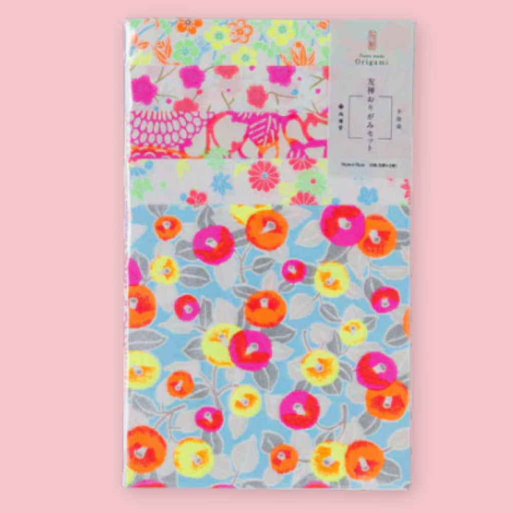 Shogado Yuzen Washi Origami Neon paper in its packaging, showing four neon floral patterns in pink, orange, yellow, and blue, against a pink background