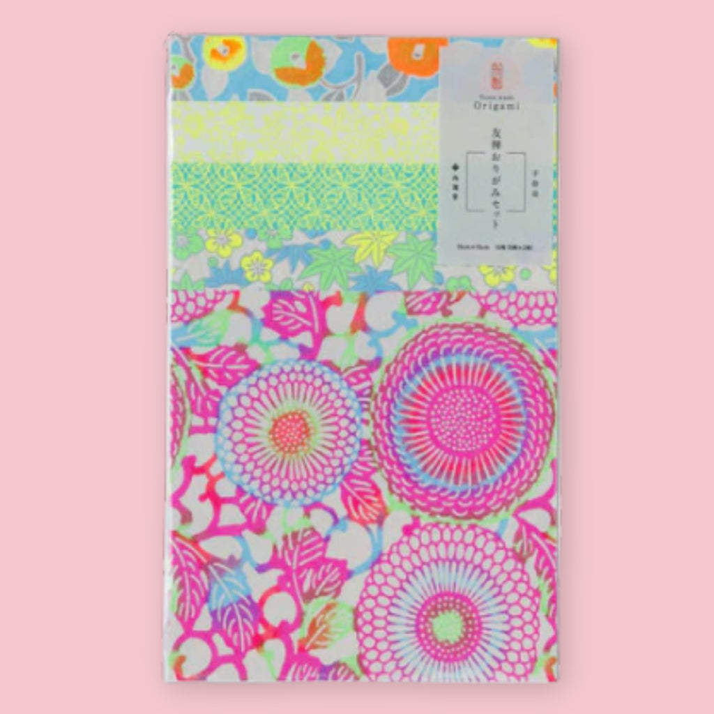 Shogado Yuzen Washi Origami Neon paper in its packaging, showing four neon floral patterns in pink, green, yellow, and blue, against a pink background