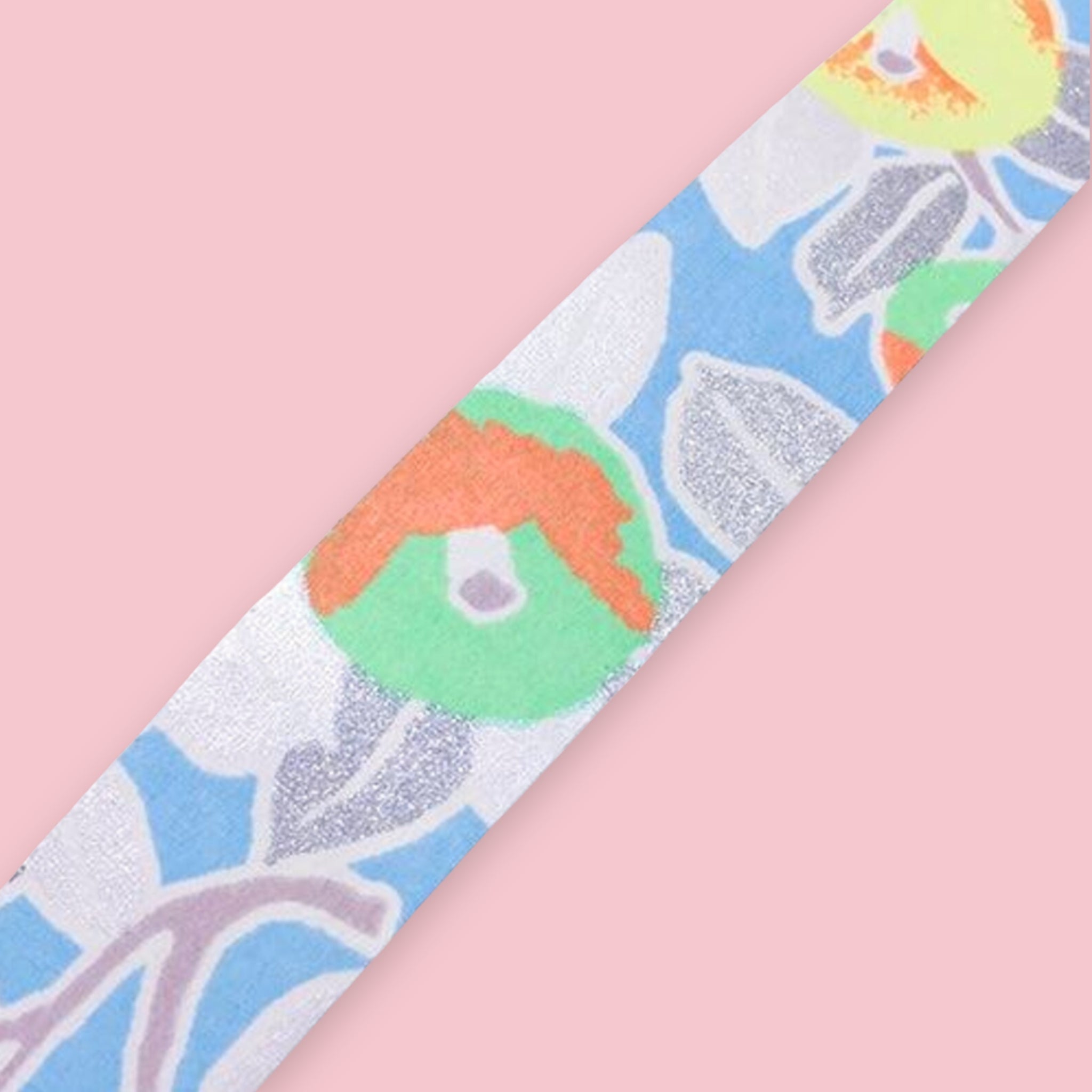 Strip of Shogado Yuzen Washi Tape in a neon floral pattern with blue, orange, and green leaf motifs on a silver textured background, against a pink background
