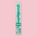 Transparent teal Moomin chopsticks decorated with small character illustrations in packaging on a pink background