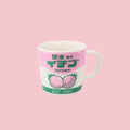 A white ceramic mug featuring a retro Japanese label design with pink and white colorblocking, bold green text reading 関東・栃木 イチゴ (Kanto Tochigi Strawberry), illustrated strawberries, and 500ml strawberry milk drink branding, displayed on a pink background.