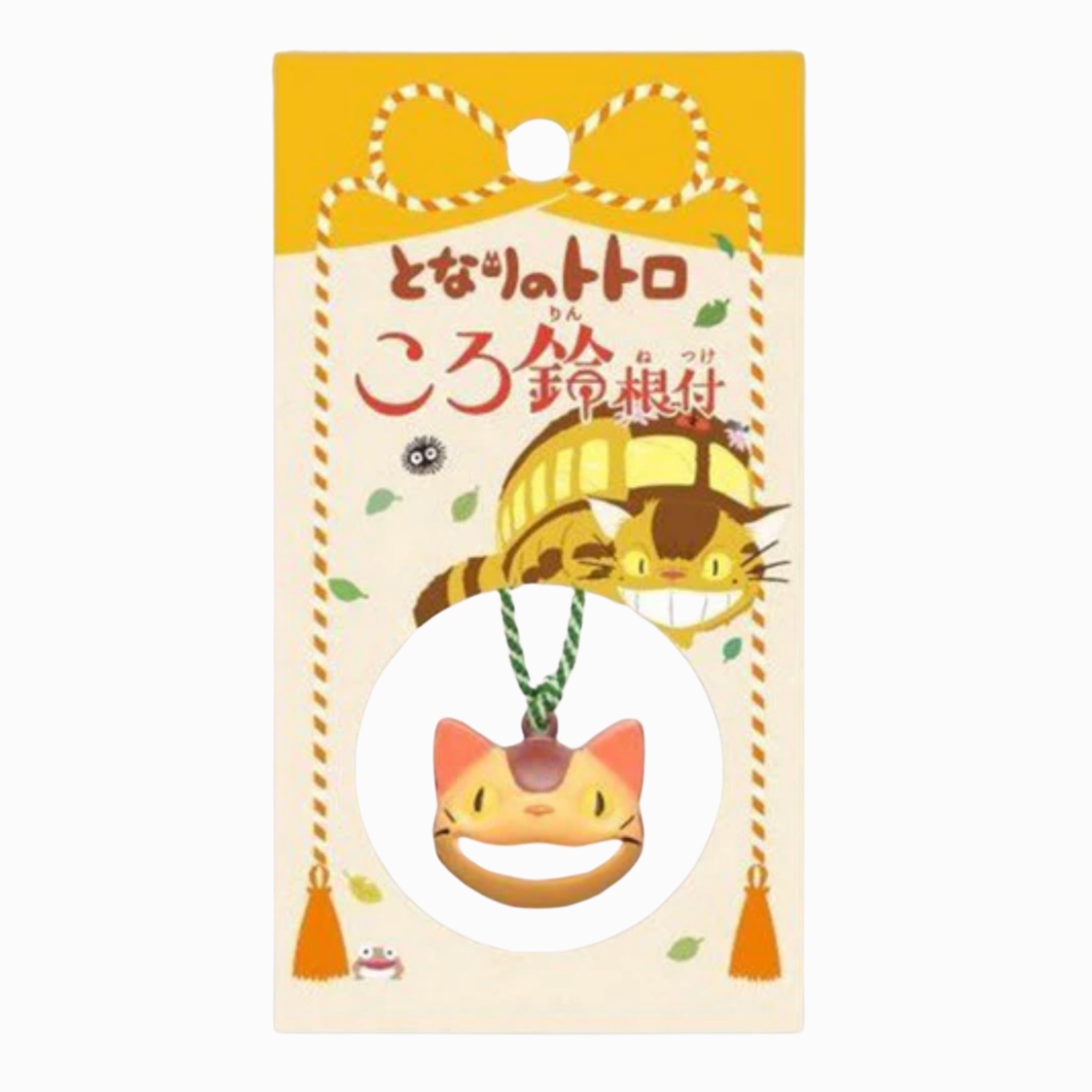Original Japanese packaging card for the My Neighbor Totoro Catbus bell charm, featuring the Catbus illustration and Japanese title in brown text on a yellow backdrop, with the smiling orange and cream Catbus bell charm shown hanging on its green cord inside a circular white window at the bottom of the card.