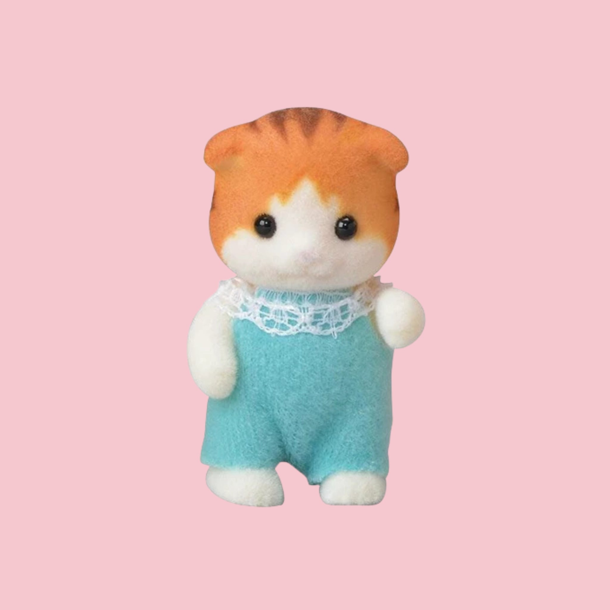 Sylvanian Families walnut cat baby figure in green outfit, shown against a pink background.